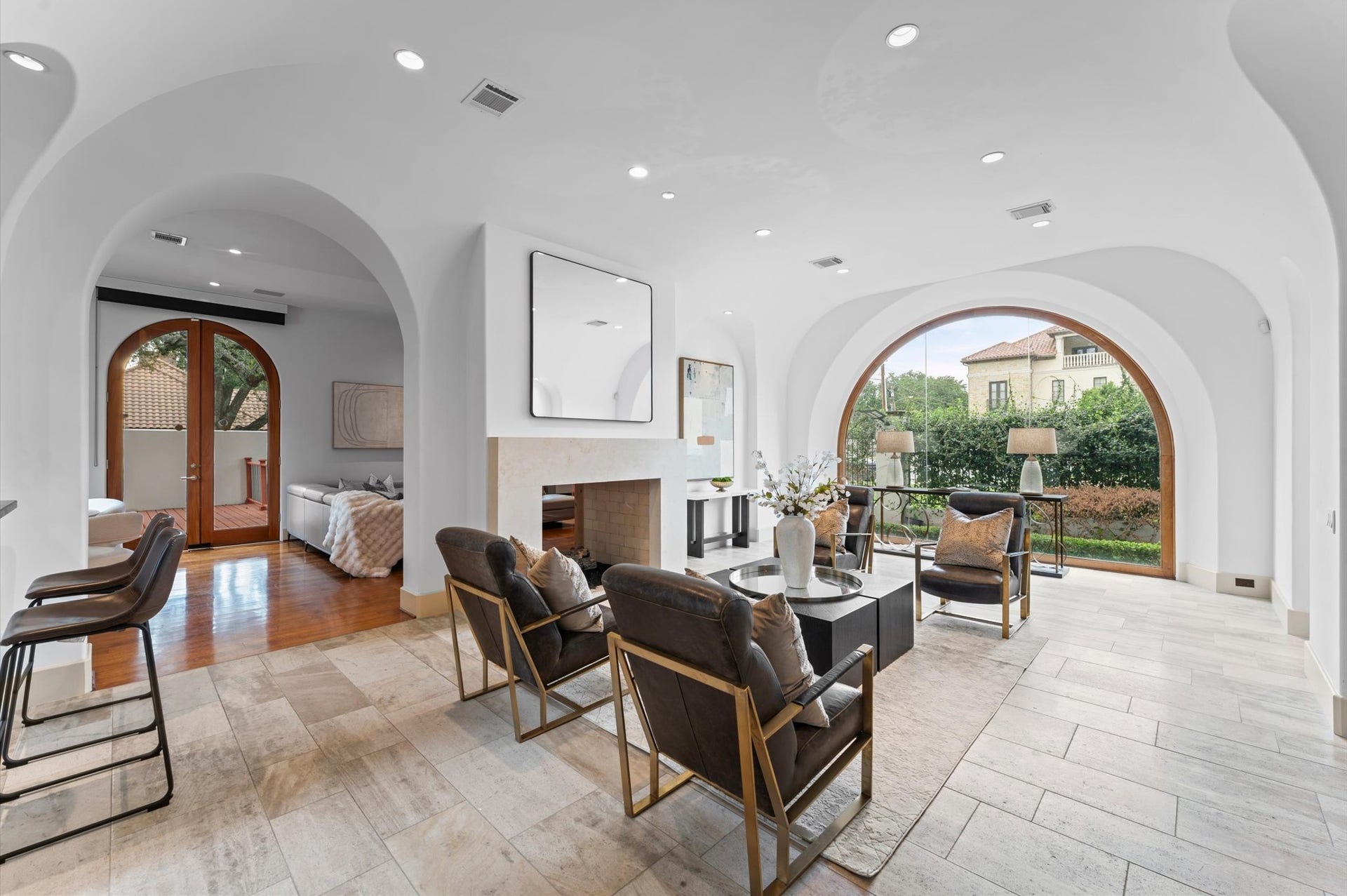 5135 Longmont Drive, Houston, TX 77056 The expansive reception gallery flows seamlessly into the double living room, unified by a shared stone fireplace and elegant imported travertine flooring.