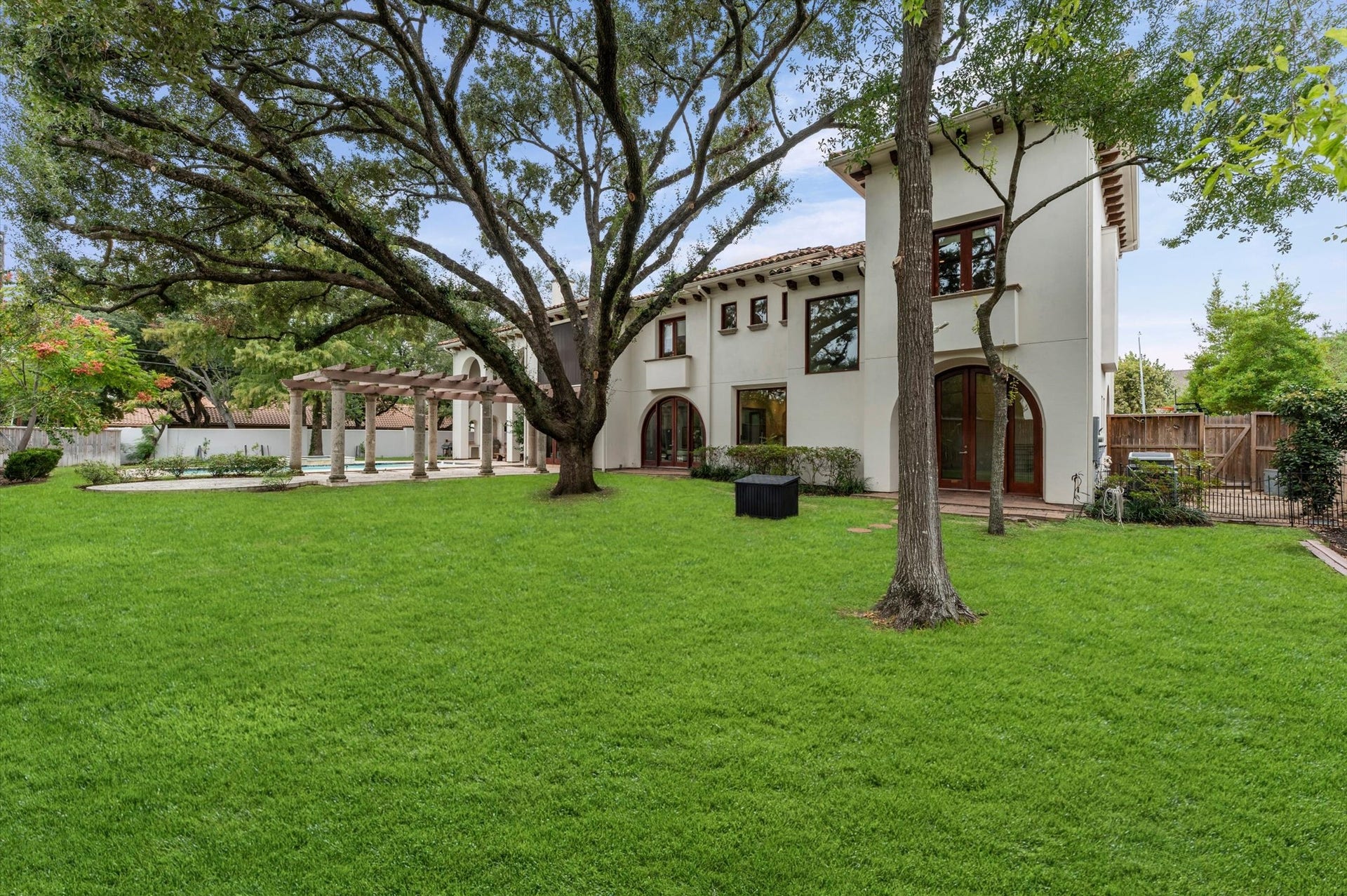 5135 Longmont Drive, Houston, TX 77056 Enjoy the beauty and privacy of expansive grounds framed by mature trees, manicured lawns, and timeless Modern Spanish architecture. The generous backyard offers a stunning setting for outdoor living, with the resort-style pool, grand pergola, and elegant arched windows completing this exceptional estate.