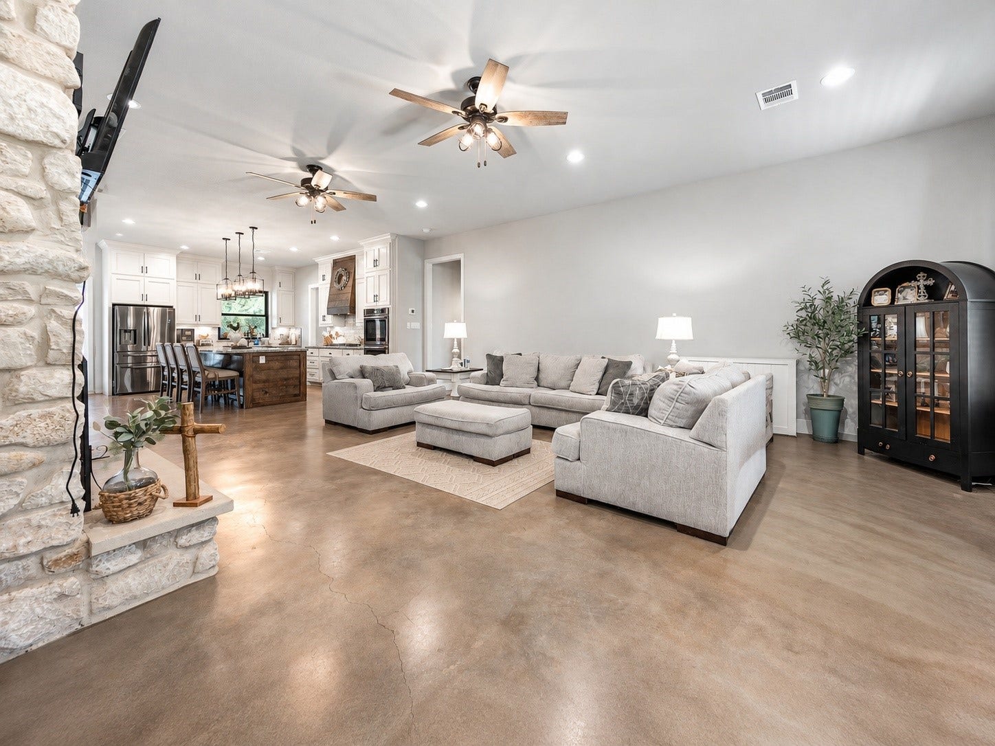 3295 Fm 524 Road, Sweeny, TX 77480 Open-concept family room with a stone fireplace, flowing into the kitchen and dining area. This photo may be edited using AI tools.
