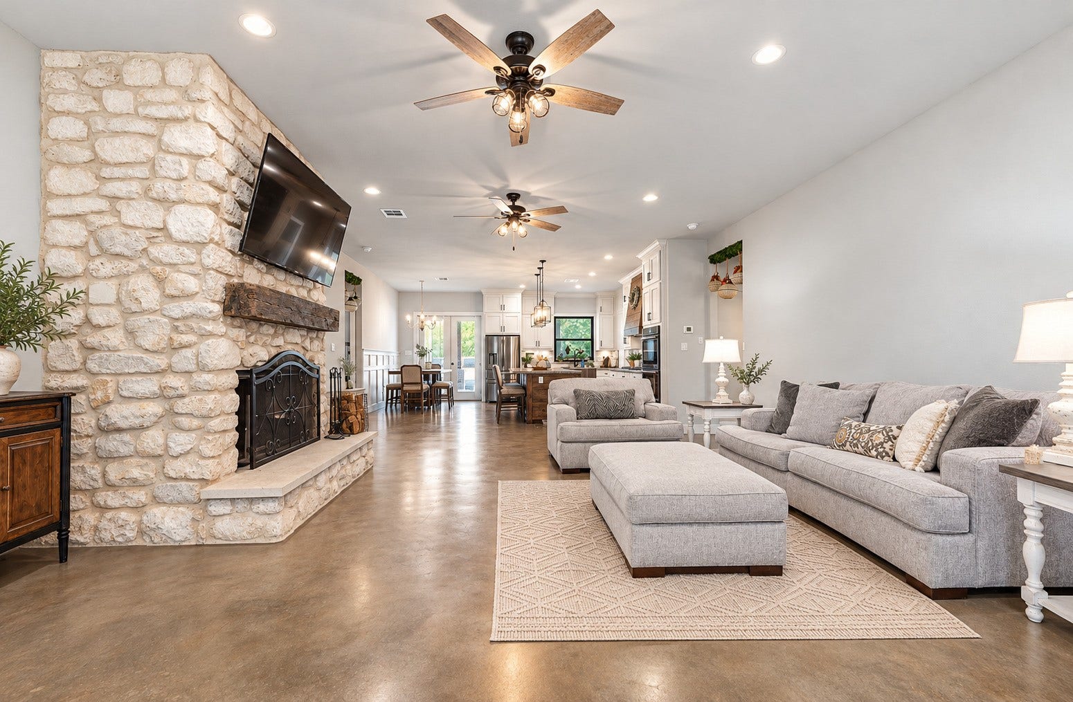 3295 Fm 524 Road, Sweeny, TX 77480 Family room with 10-ft ceilings, stained concrete floors and a floor-to-ceiling stone fireplace. This photo may be edited using AI tools.