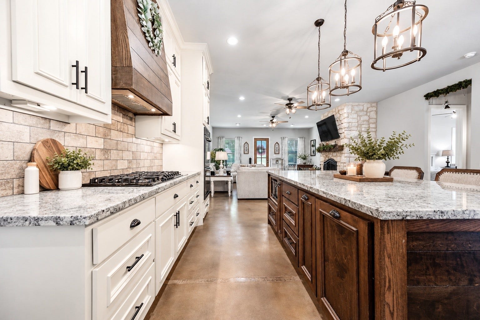 3295 Fm 524 Road, Sweeny, TX 77480 Kitchen with white custom cabinetry, granite countertops, stone-look backsplash, wood range hood and a large stained wood island. This photo may be edited using AI tools.