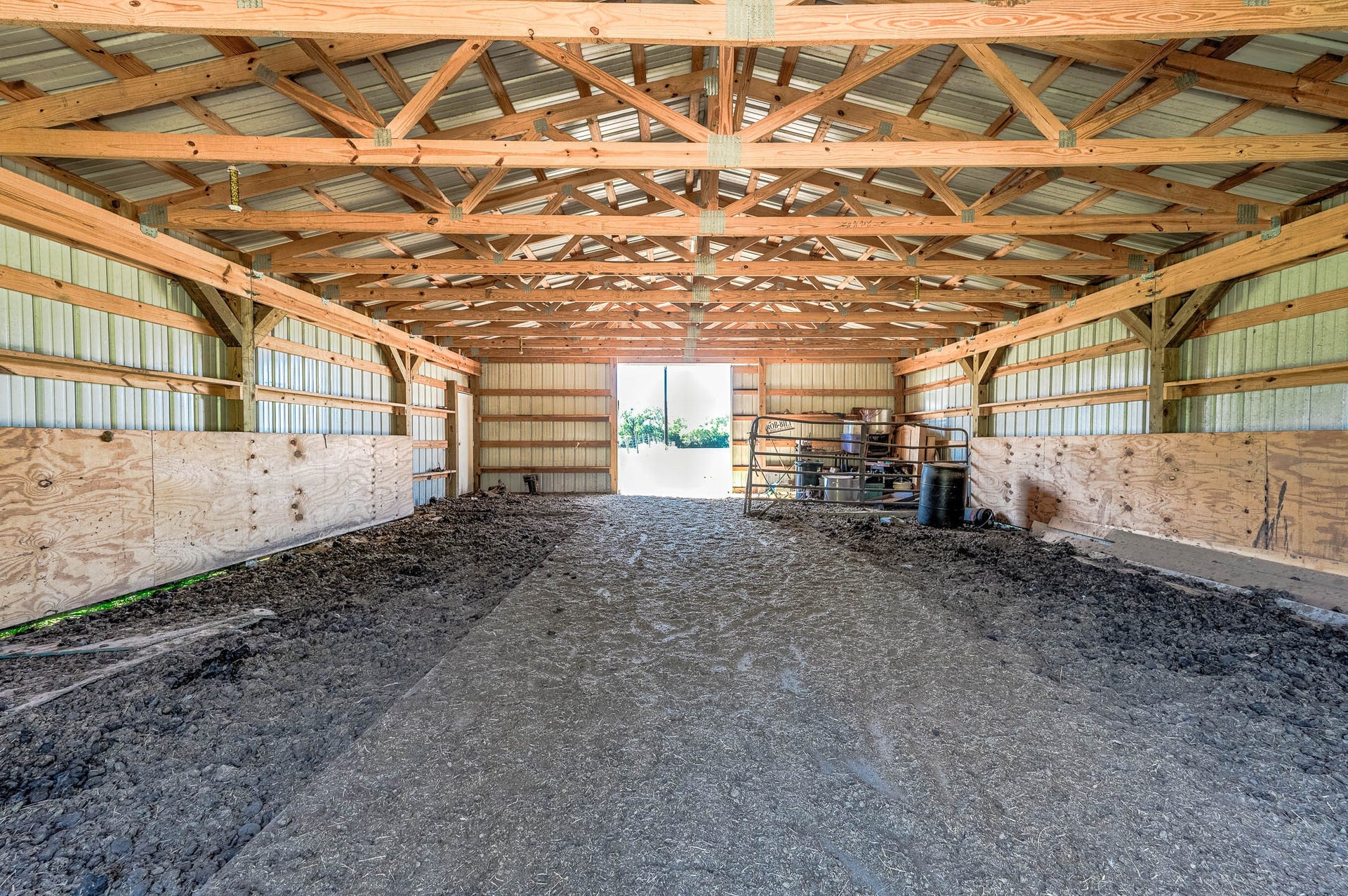 3295 Fm 524 Road, Sweeny, TX 77480 Barn interior with open center aisle, ready for stalls, tack or equipment storage. This photo may be edited using AI tools.