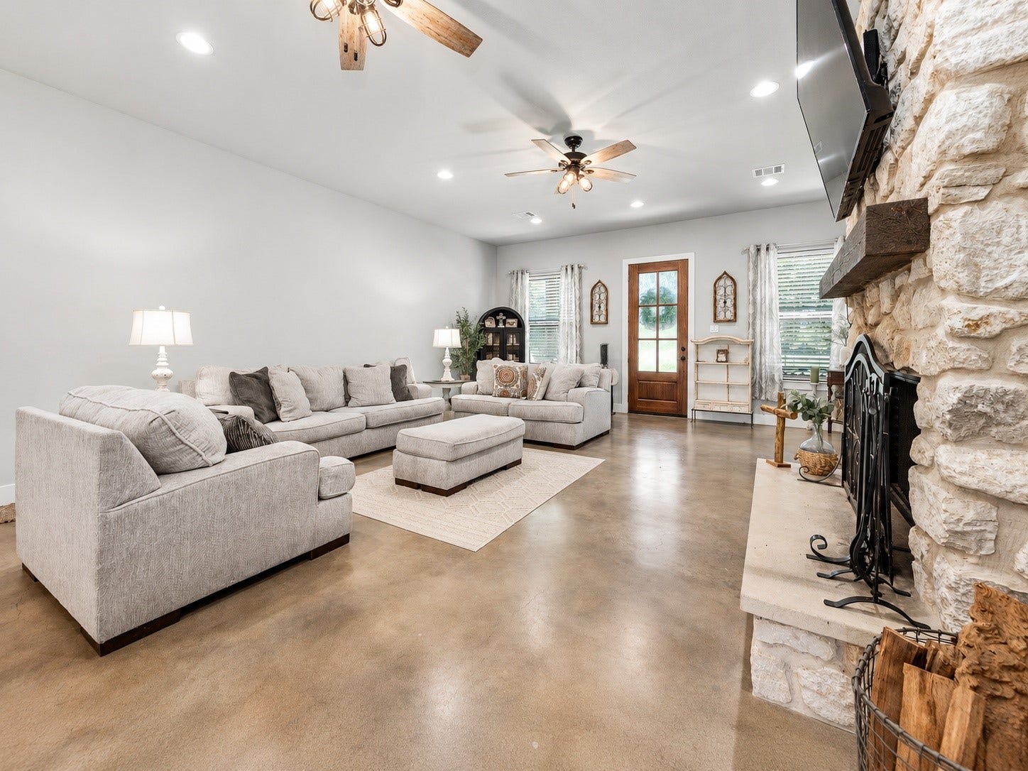 3295 Fm 524 Road, Sweeny, TX 77480 Open family room looking toward the front entry, with stained concrete floors, high ceilings and natural light. This photo may be edited using AI tools.