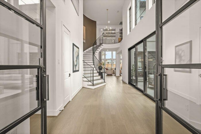 7114 Quaker Meadows Drive, Katy, TX 77493 The dazzling grand entry with a curved staircase and courtyard views. Representative image.