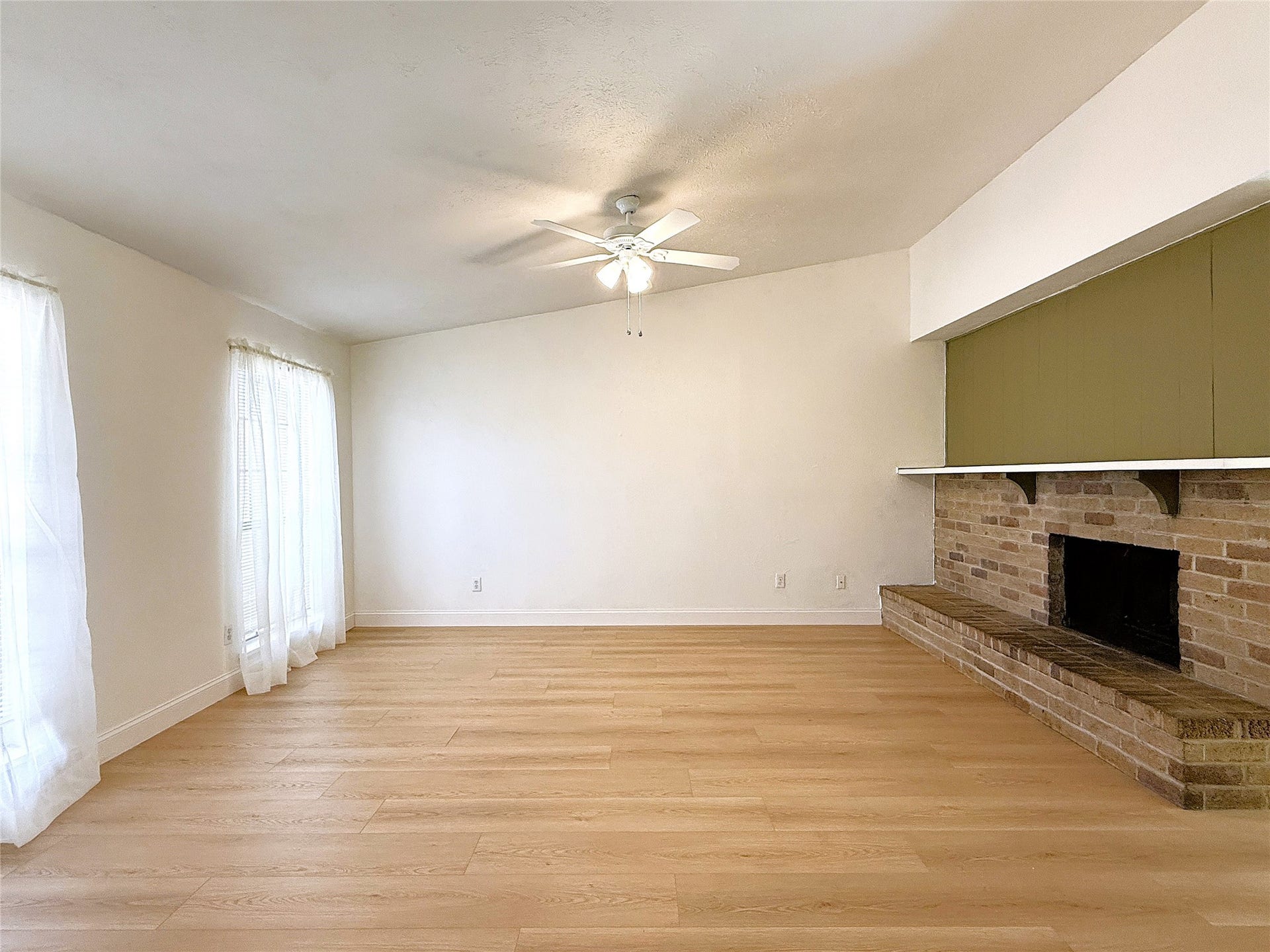 7526 Goldfinch Drive, Humble, TX 77396 Spacious living with woodburning fireplace and laminate flooring.