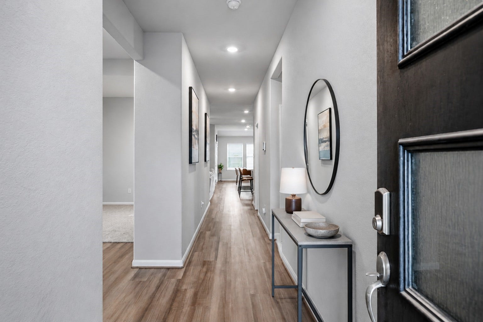903 Pismo Lane, Rosharon, TX 77583 Virtually Staged: This inviting entryway features a long, open hallway with soft neutral walls, elegant wood-look flooring, and recessed ceiling lighting that creates a bright, welcoming atmosphere.