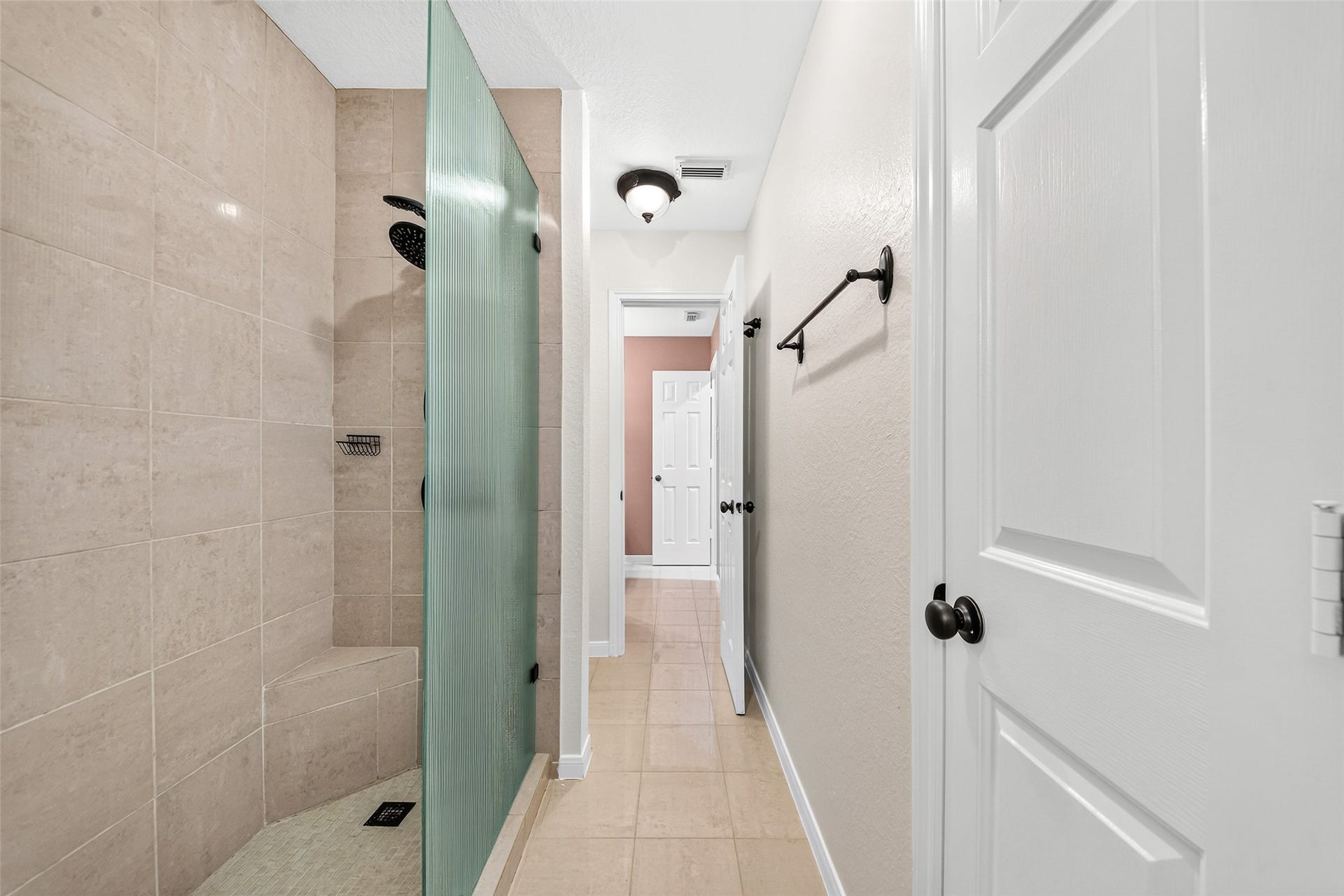 9515 Sotherloch Lake Drive, Spring, TX 77379 Secondary bathroom with gorgeous tiled shower! Updated bronze hardware and lighting.