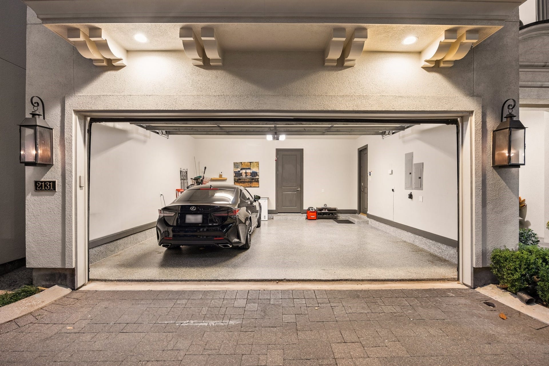 2131 Bancroft Street, Houston, TX 77027 Spacious two-car garage featuring high ceilings, durable epoxy flooring, and additional storage in a separate walk-in storage room.