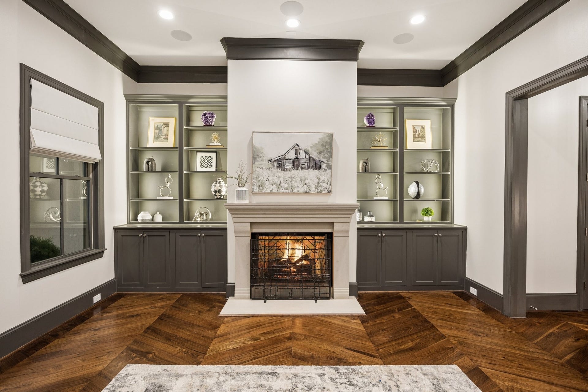 2131 Bancroft Street, Houston, TX 77027 Elegant gas fireplace framed by custom built-in cabinetry with dimmable shelf lighting, creating a warm, sophisticated ambiance and a beautiful focal point for the formal living room.