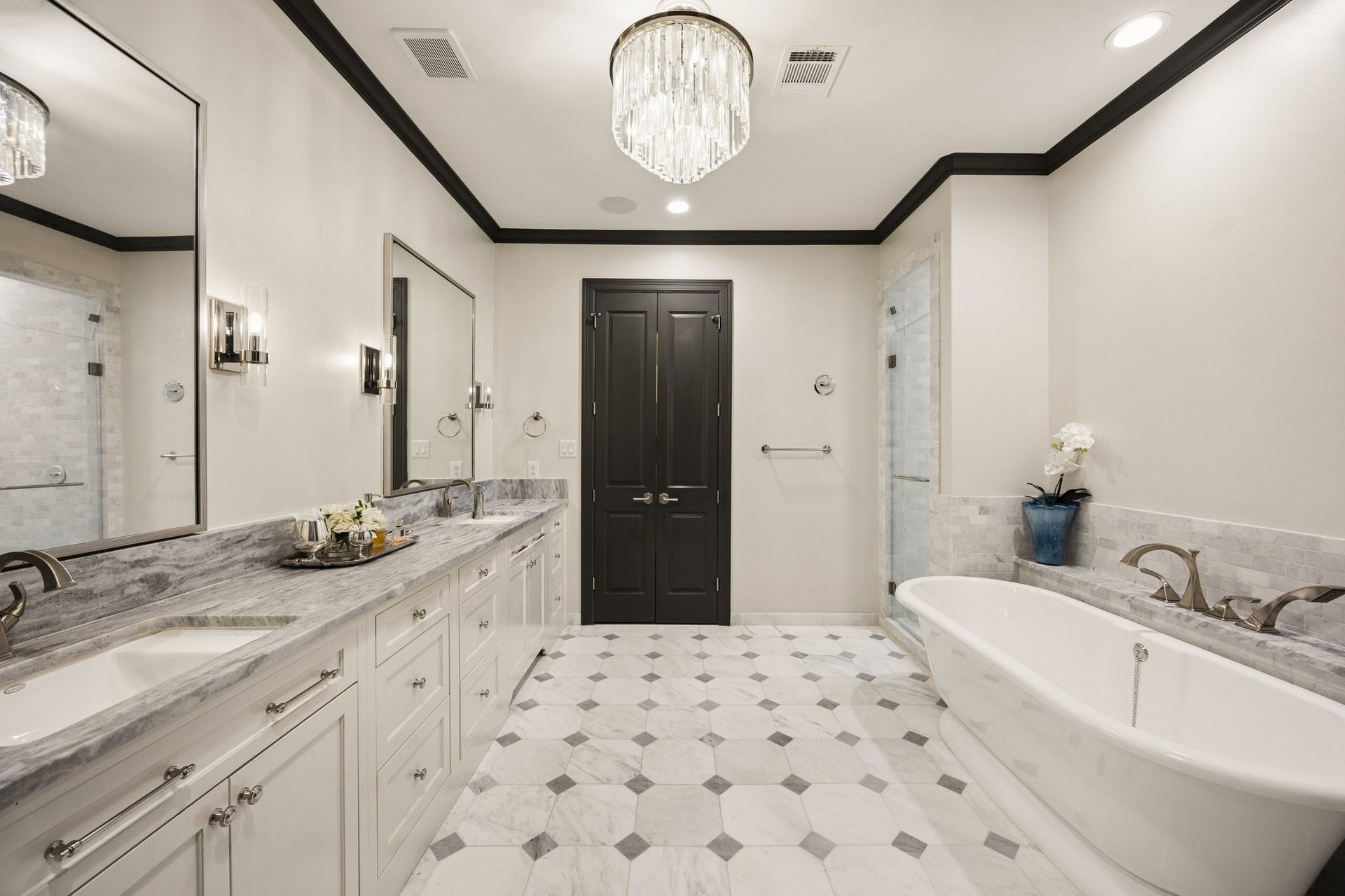 2131 Bancroft Street, Houston, TX 77027 Luxurious primary bathroom featuring dual vanities, marble countertops, designer lighting, and two spacious walk-in closets with custom California Closets organization systems and built-ins.