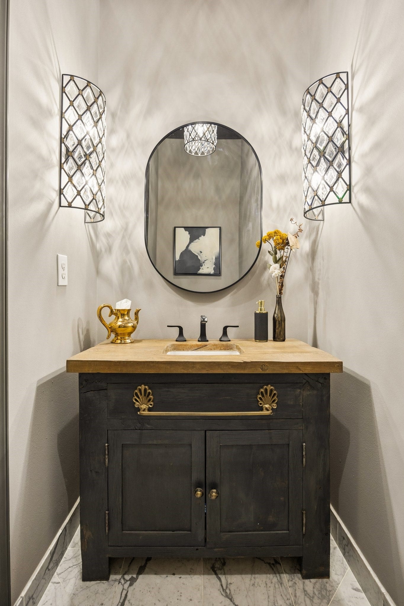 2131 Bancroft Street, Houston, TX 77027 Elegant powder room featuring a custom vanity with natural stone countertop, decorative vessel sink, designer wall sconces, and a statement mirror.
