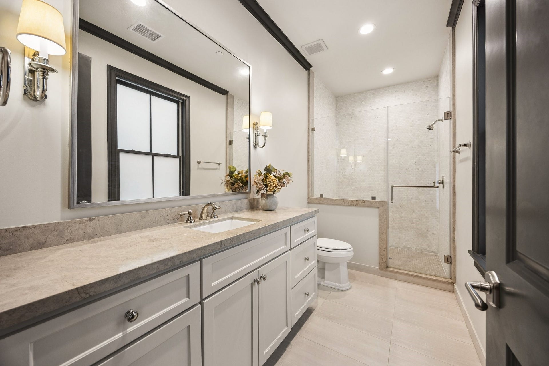 2131 Bancroft Street, Houston, TX 77027 Elegant secondary bedroom en-suite bathroom featuring a spacious stone countertop vanity, custom cabinetry, and a beautifully tiled glass-enclosed walk-in shower.