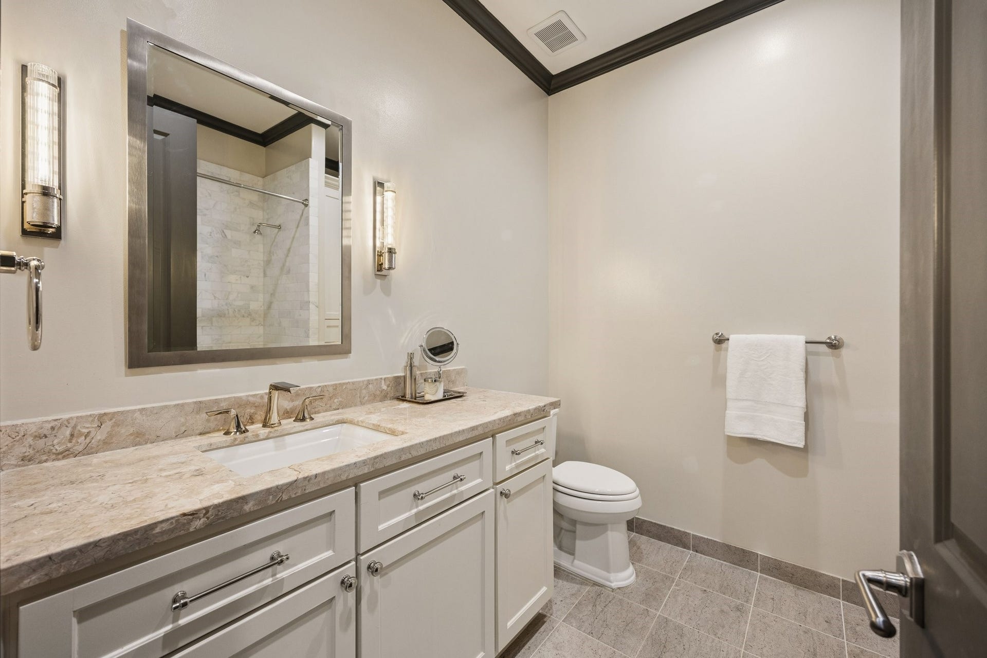 2131 Bancroft Street, Houston, TX 77027 Elegant first-floor en-suite bathroom featuring a stone countertop, custom vanity, and a beautifully tiled tub and shower combination.
