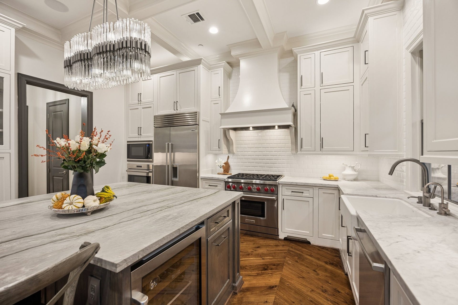 2131 Bancroft Street, Houston, TX 77027 Beautifully appointed kitchen featuring a professional-grade Wolf gas range, custom vent hood, farmhouse sink, elegant coffered ceiling, and exquisite craftsmanship throughout.