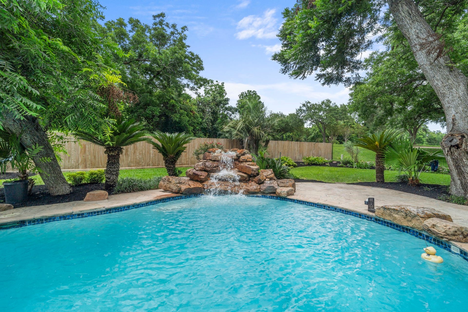 75 Stalybridge Street, Sugar Land, TX 77479 A cascading rock waterfall creates a beautiful focal point, adding movement & sound to the pool setting while mature trees frame the backyard.