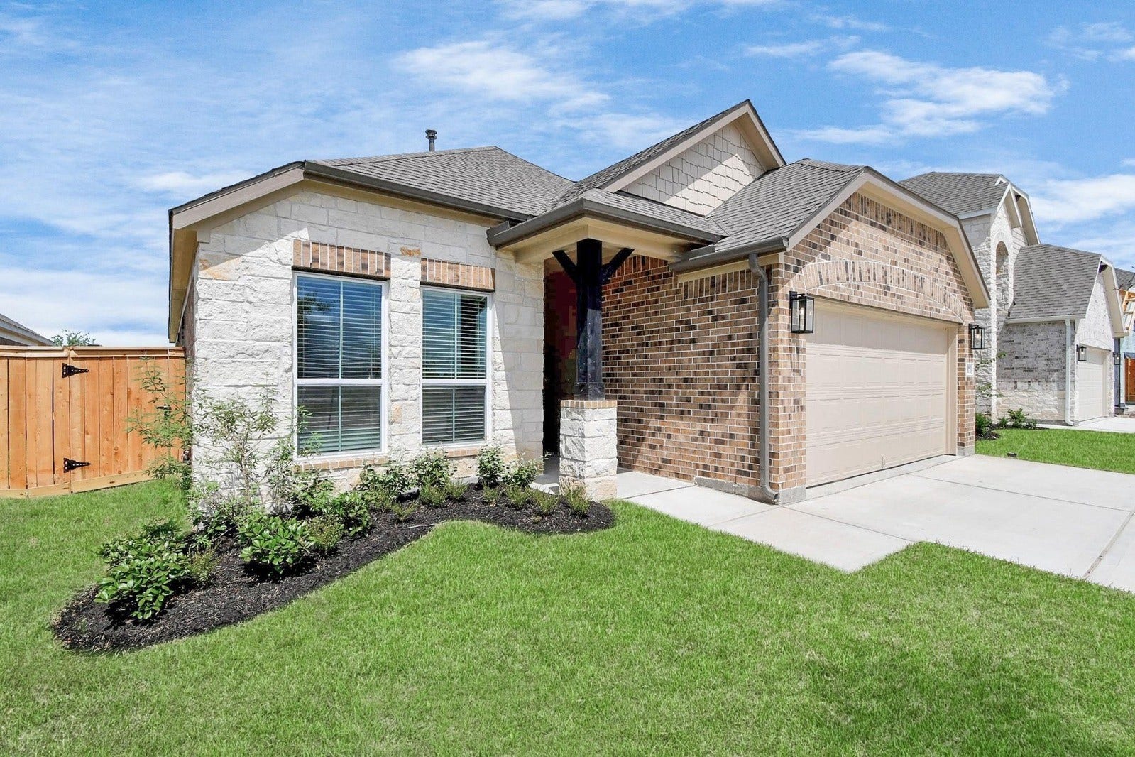 15611 Kirkton Raye Drive, Humble, TX 77346 This home features an elegant front elevation with a charming blend of brick and stone accents, complemented by a well-manicured lawn and inviting entryway.