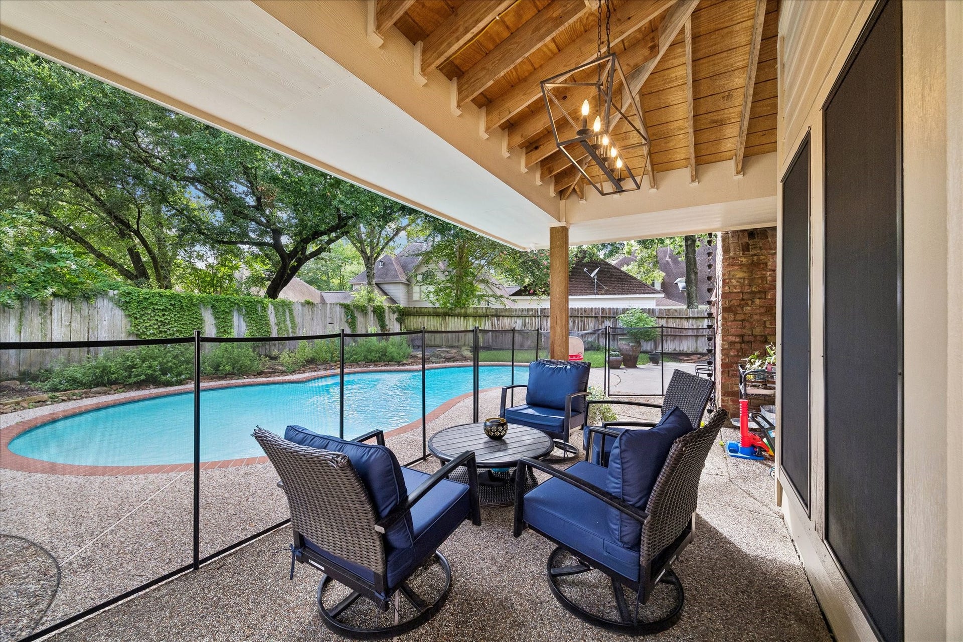 2411 Kings Lodge Drive, Kingwood, TX 77345 Charming new covered patio was recently added and is perfect for famly lounging and entertaining as it overlooks a sparkling pool, surrounded by lush greenery for a serene outdoor retreat. Removable safety fence also includes a pool safety net.