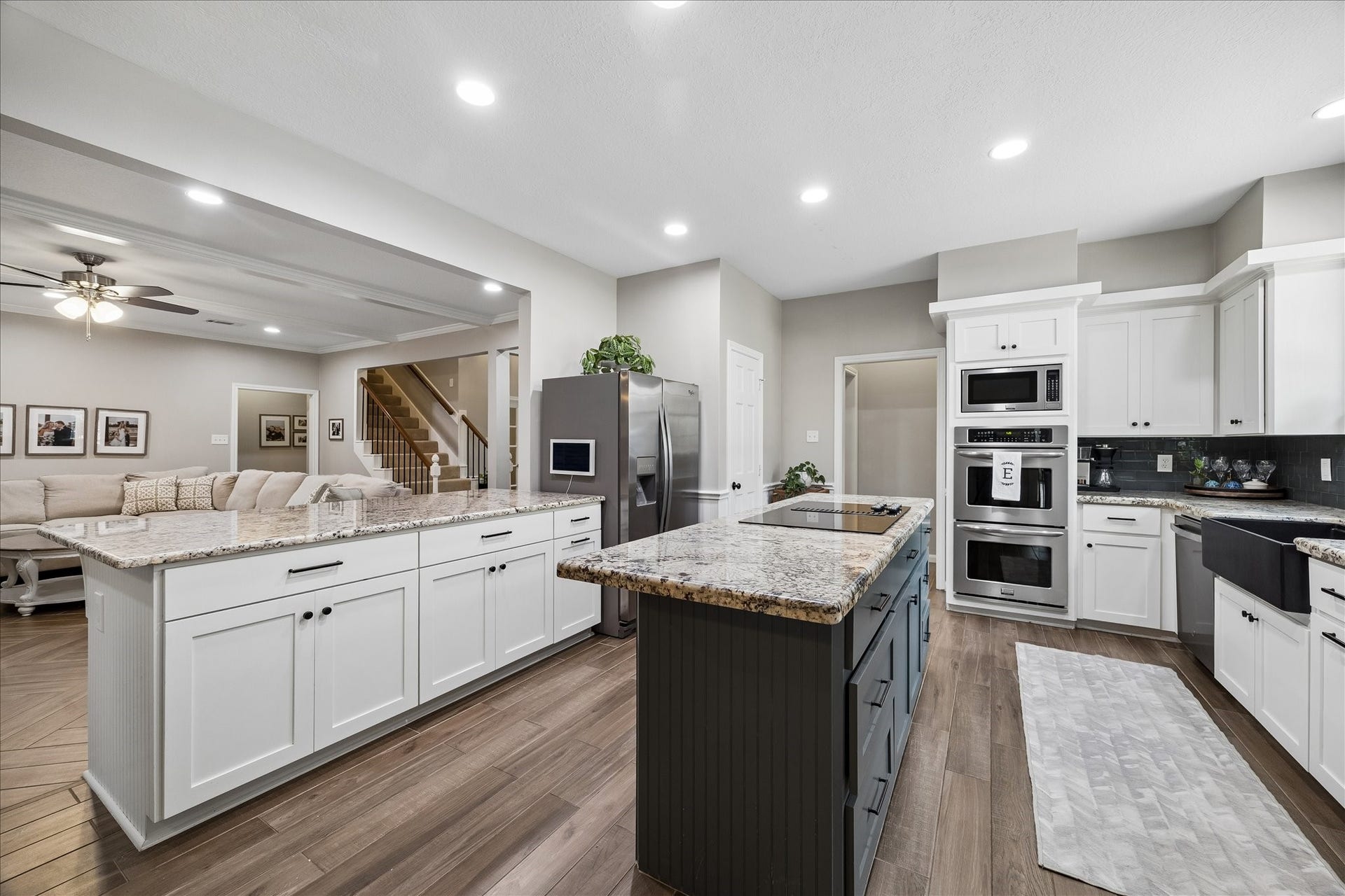 2411 Kings Lodge Drive, Kingwood, TX 77345 Spacious modern kitchen (renovated in 2025) with granite countertops, stainless steel appliances, and a large central island. Open layout flows seamlessly into a cozy living area.