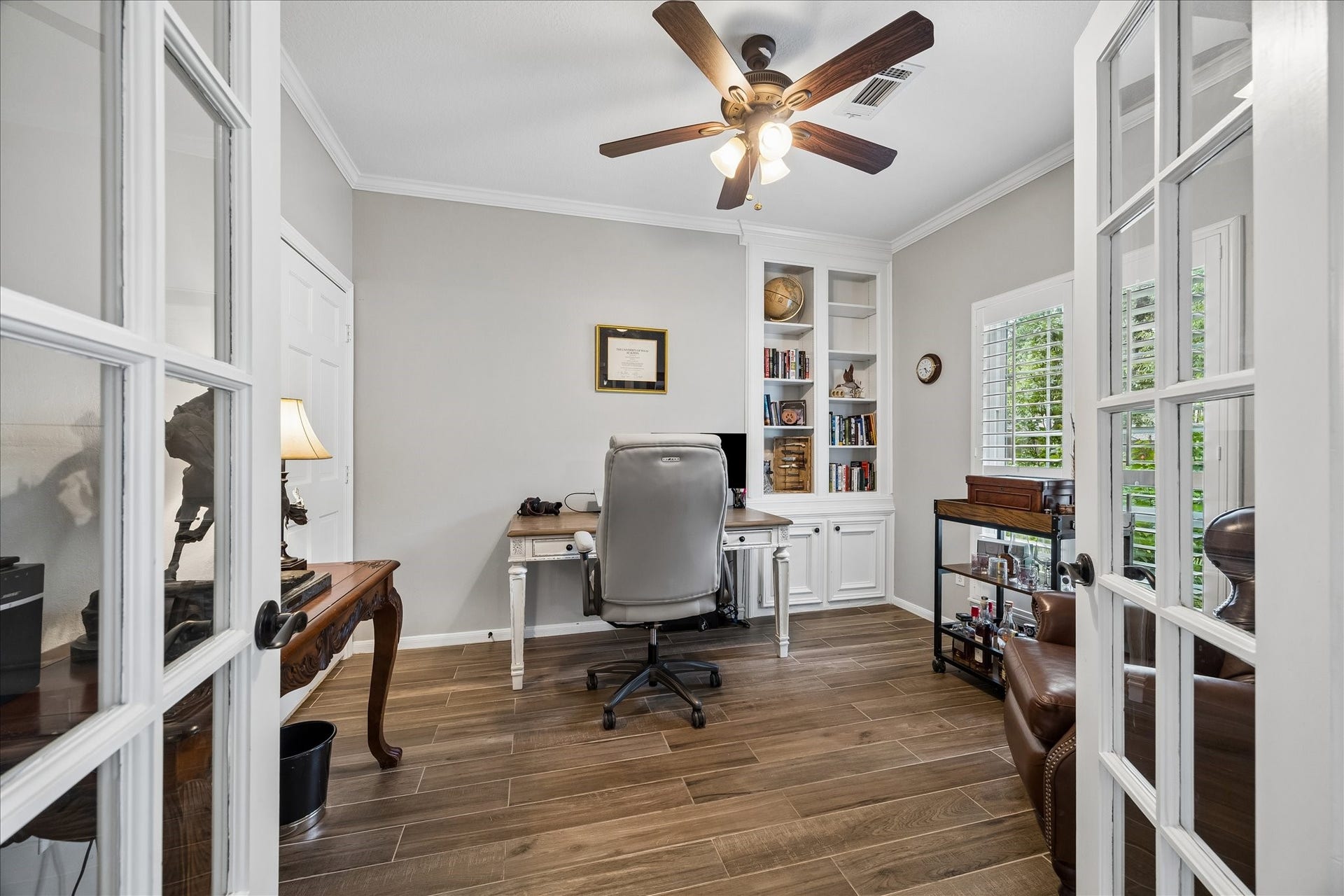 2411 Kings Lodge Drive, Kingwood, TX 77345 Charming home office featuring elegant French doors, warm wood flooring, and ample natural light, creating an inviting workspace or for an extra and more private social lounge area.