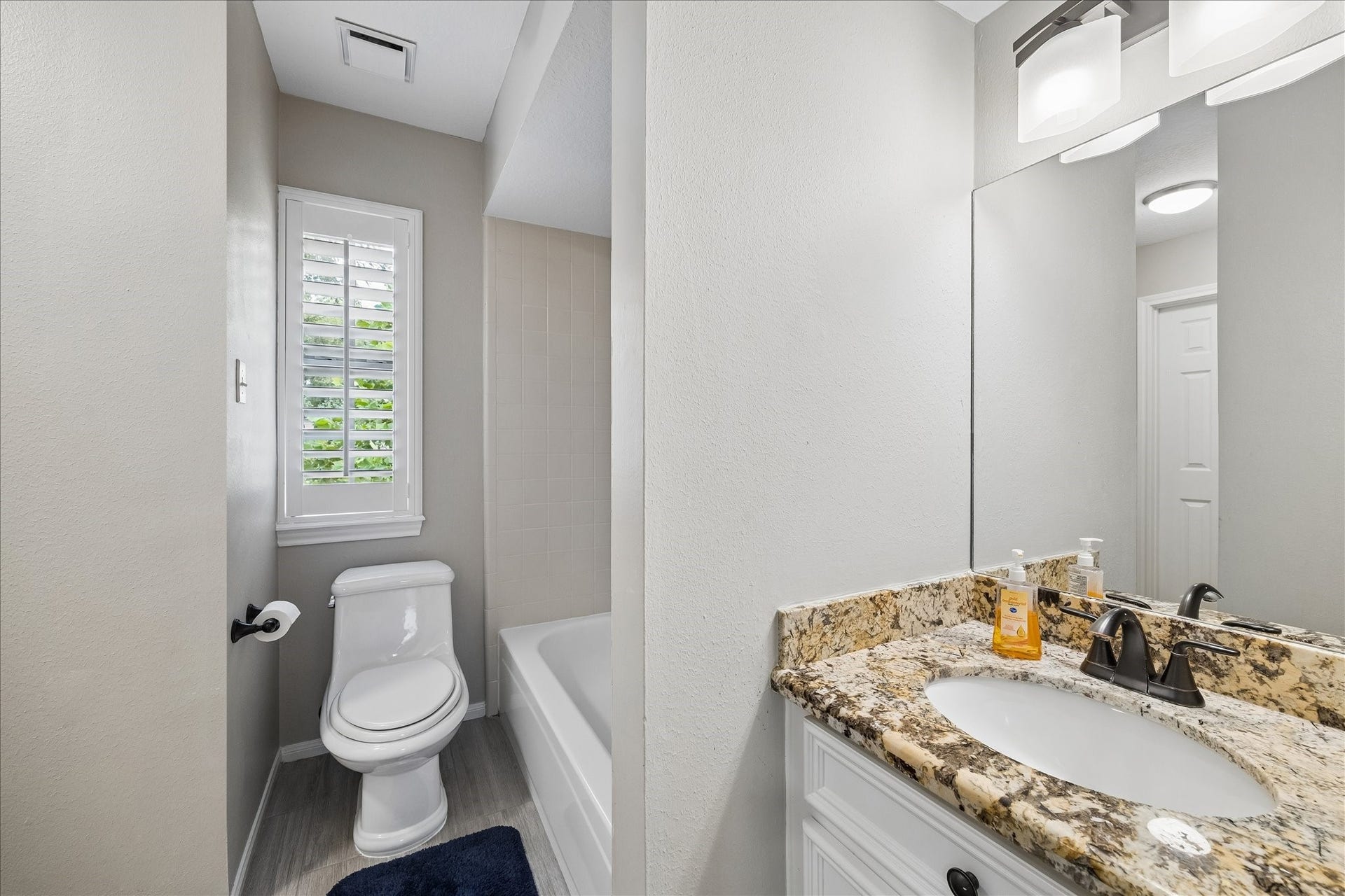 2411 Kings Lodge Drive, Kingwood, TX 77345 Bright and inviting full bathroom off of the gameroom features granite countertop, sleek fixtures, and natural light streaming through plantation shutters.
