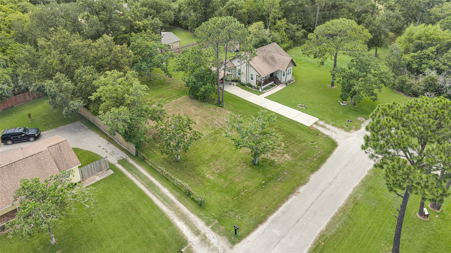 6519 Pinecrest Drive, Hitchcock, TX 77563 Charming home nestled among mature trees with a spacious front yard and a long driveway offering ample parking.