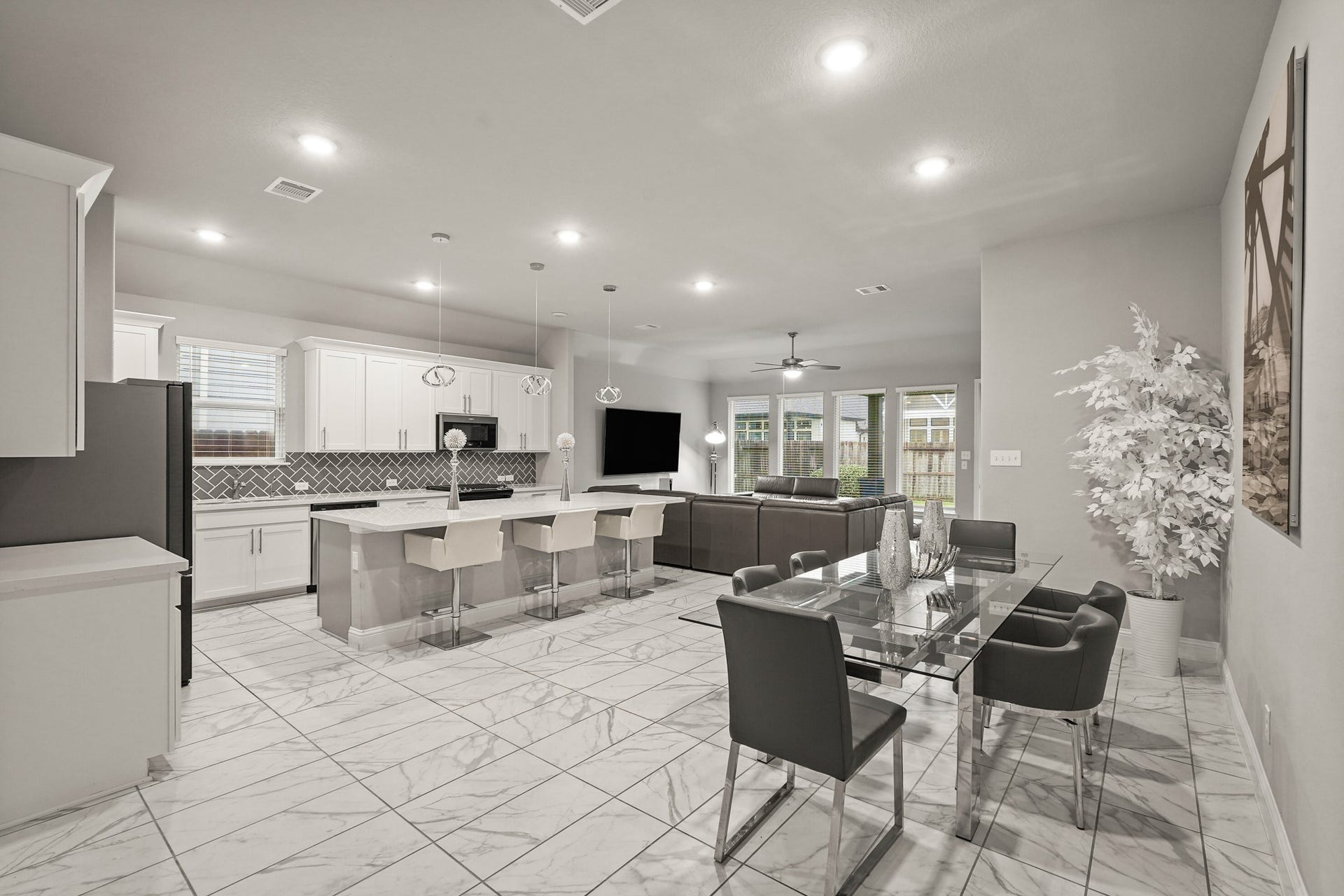 1710 Forest Mist Drive, Missouri City, TX 77459 A wide-angle view of the open-concept main floor, highlighting a modern kitchen with a massive island, and a spacious dining area.