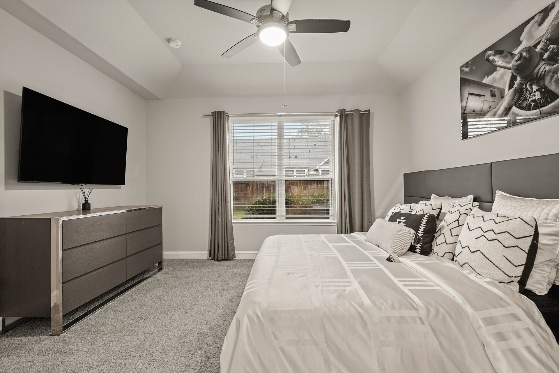 1710 Forest Mist Drive, Missouri City, TX 77459 This spacious master bedroom offers a comfortable and modern retreat with a clean, and thoughtful design elements throughout. The room features plush carpeting, soaring ceilings, and a large window that fills the space with natural light while providing views of the backyard.