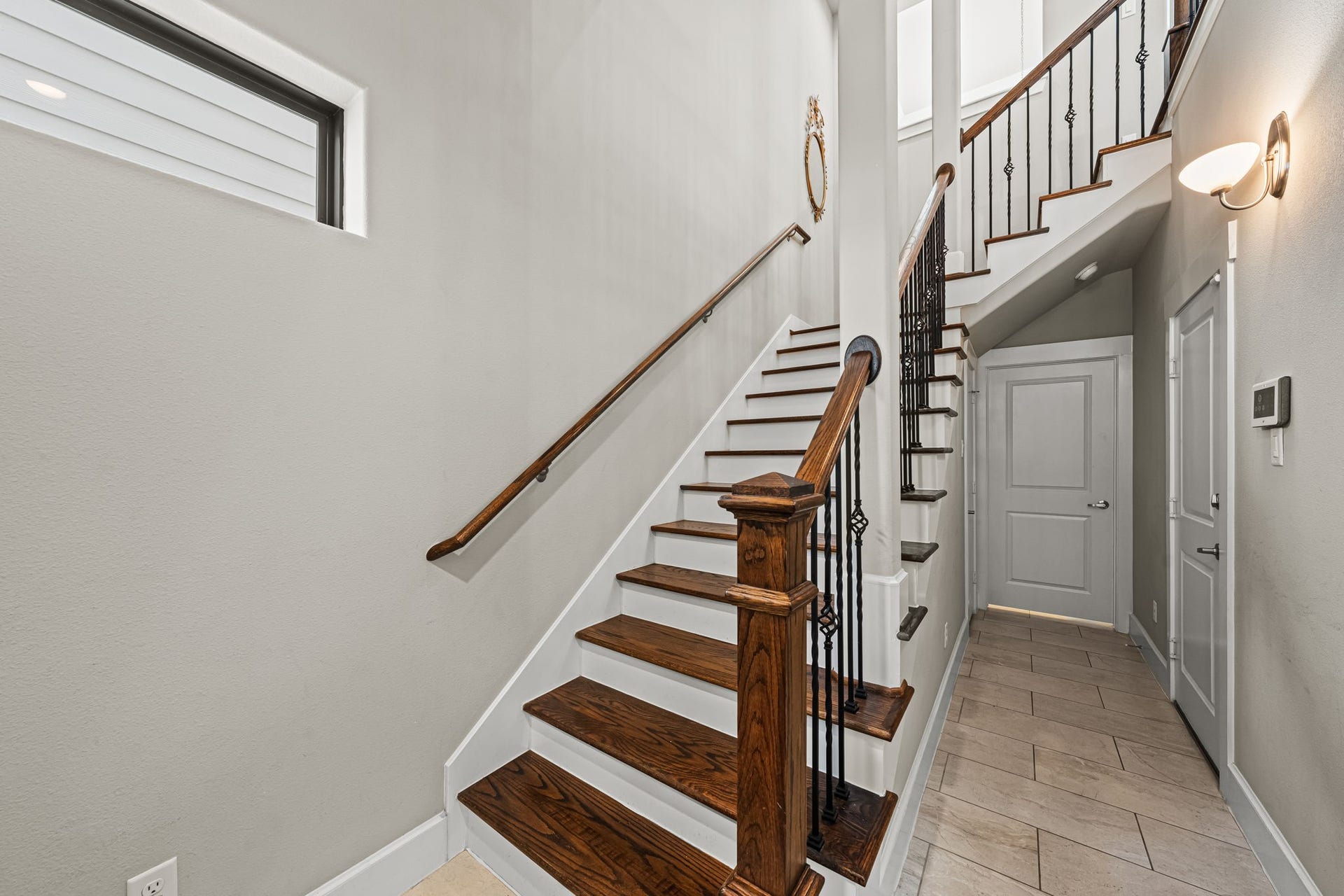 868 Wakefield Drive, #B, Houston, TX 77018 Rich wood treads and intricate iron balusters distinguish the foyer's beautifully detailed staircase. Pale tile and crisp white trim keep the entrance bright and composed.