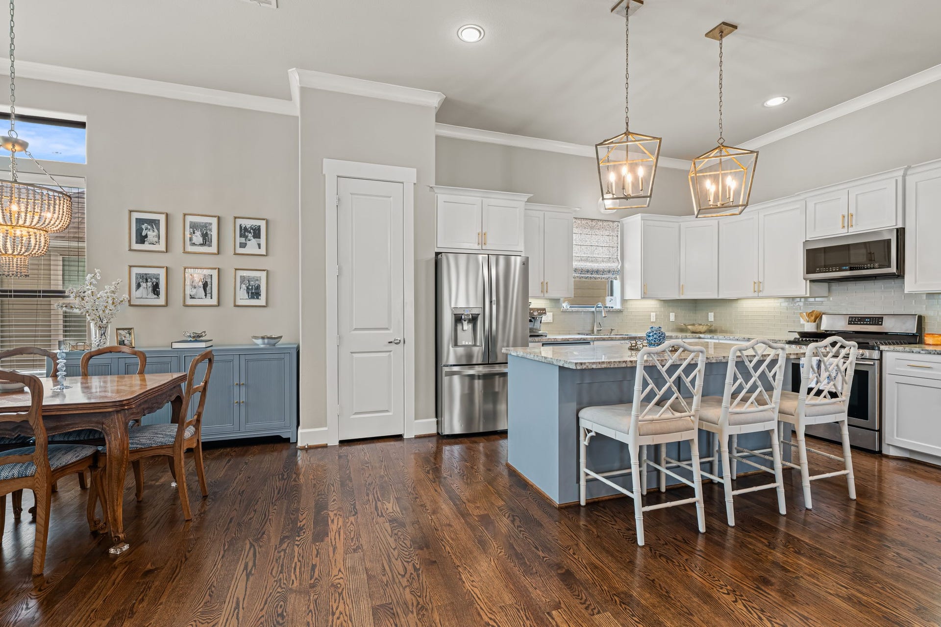 868 Wakefield Drive, #B, Houston, TX 77018 A blue island brings a distinctive note of color to the kitchen beneath a pair of designer lantern pendants. White cabinetry, stainless-steel appliances, and a softly textured backsplash complete the inviting palette. Note the custom window treatment.