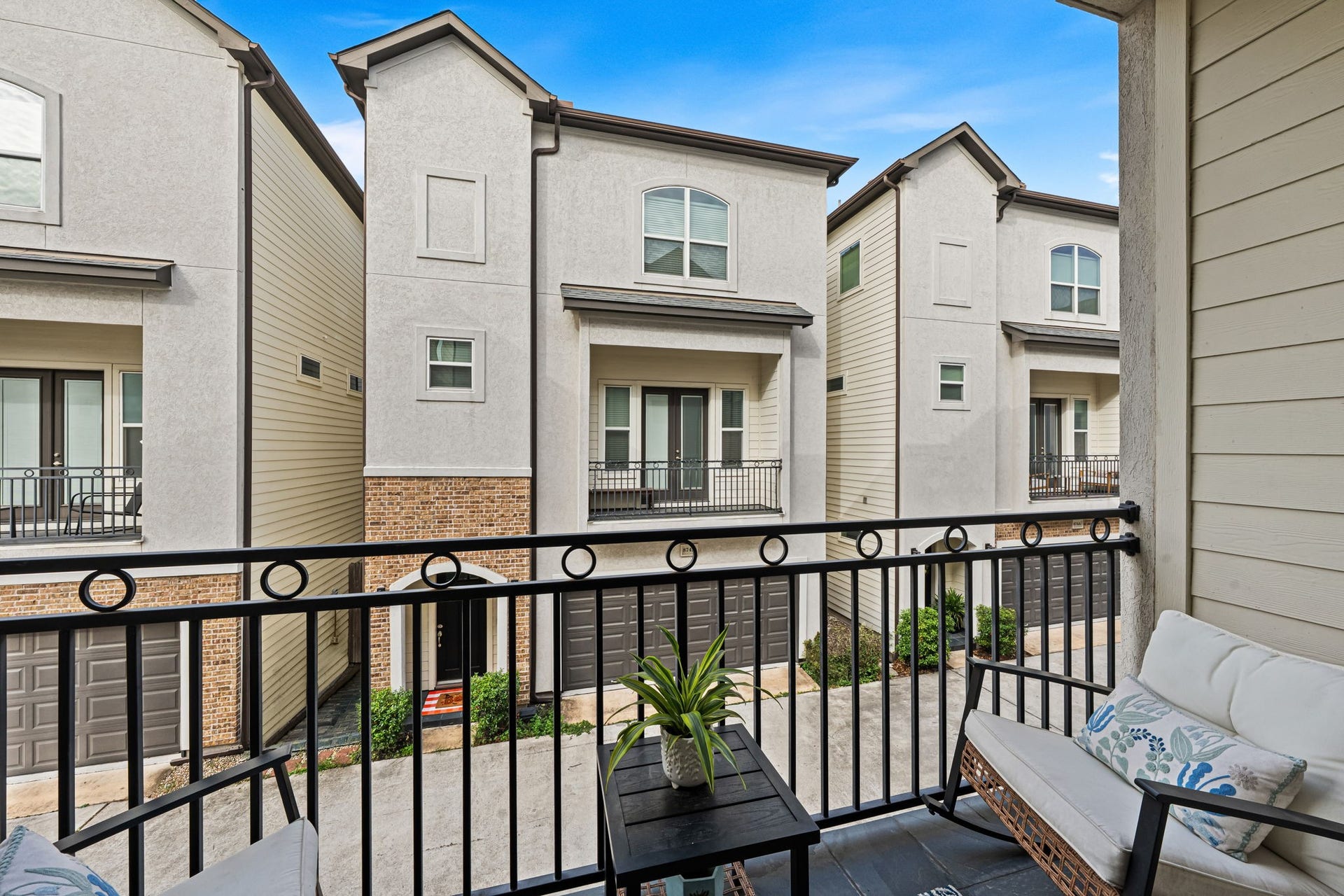868 Wakefield Drive, #B, Houston, TX 77018 The covered balcony offers a sheltered perch for morning coffee or a pause at sunset. Dark metal railings frame the outlook across the neighboring homes.