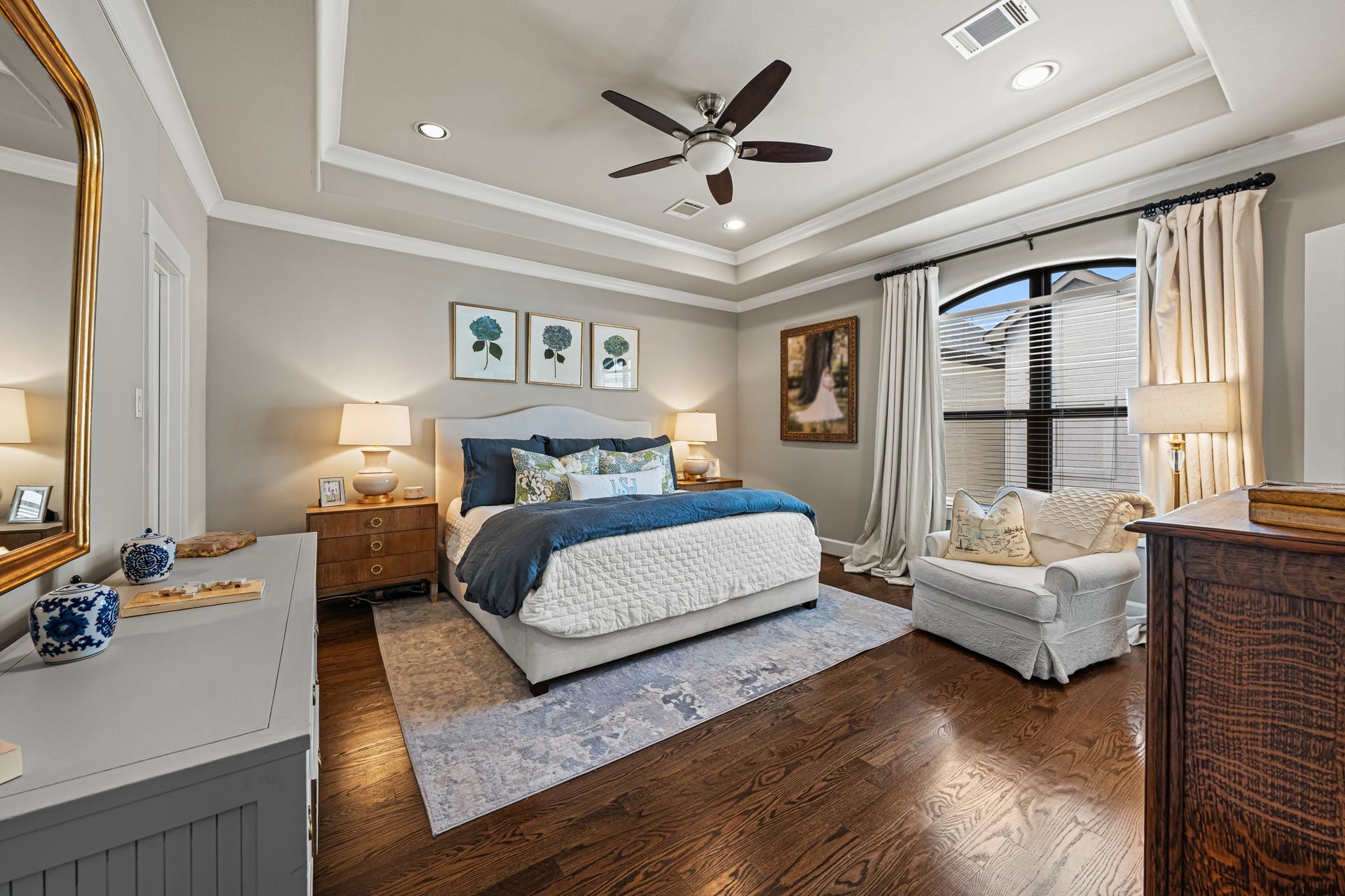 868 Wakefield Drive, #B, Houston, TX 77018 A beautifully recessed tray ceiling crowns the primary bedroom, where warm hardwoods meet a serene neutral palette. Broad windows fill this private retreat with soft natural light.