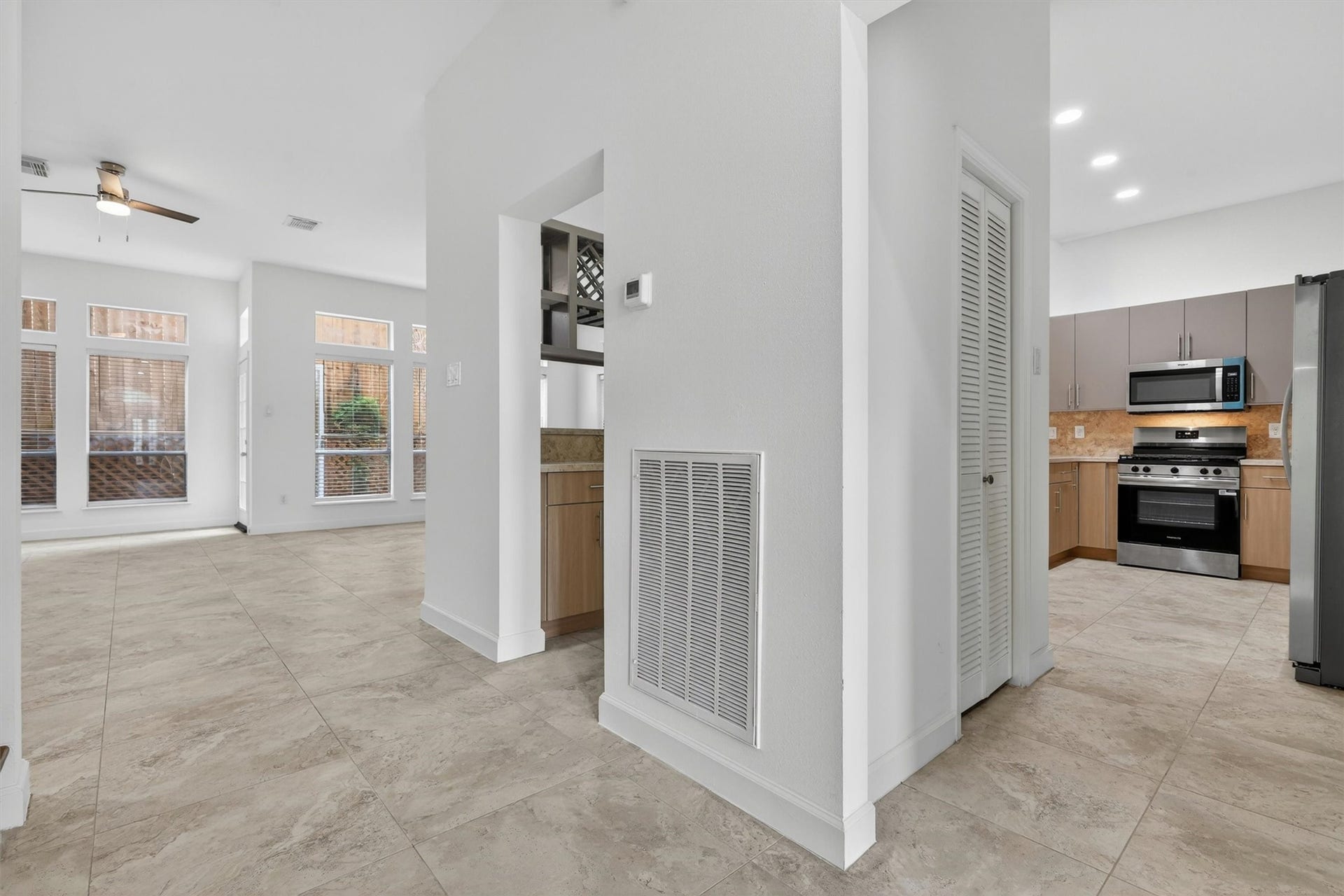 4720 Post Oak Timber Drive, #23, Houston, TX 77056 Bright and open-concept living area with high ceilings, large windows for natural light, tile flooring throughout, and seamless flow into the kitchen featuring stainless steel appliances, gas range, recessed lighting, and modern cabinetry. Neutral tones and spacious layout create the perfect setting for entertaining and everyday living.