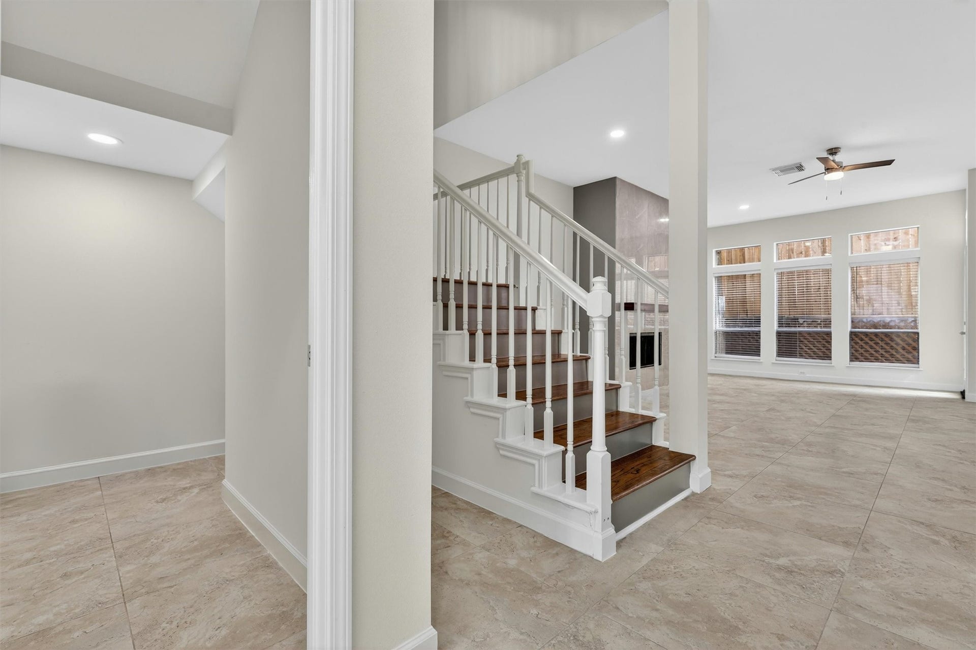 4720 Post Oak Timber Drive, #23, Houston, TX 77056 Elegant entryway with upgraded staircase, wood stair treads, soaring ceilings, and open-concept design leading into the spacious living area. Abundant natural light, tile flooring throughout main areas, recessed lighting, and modern finishes create a bright and inviting atmosphere perfect for entertaining and everyday living.