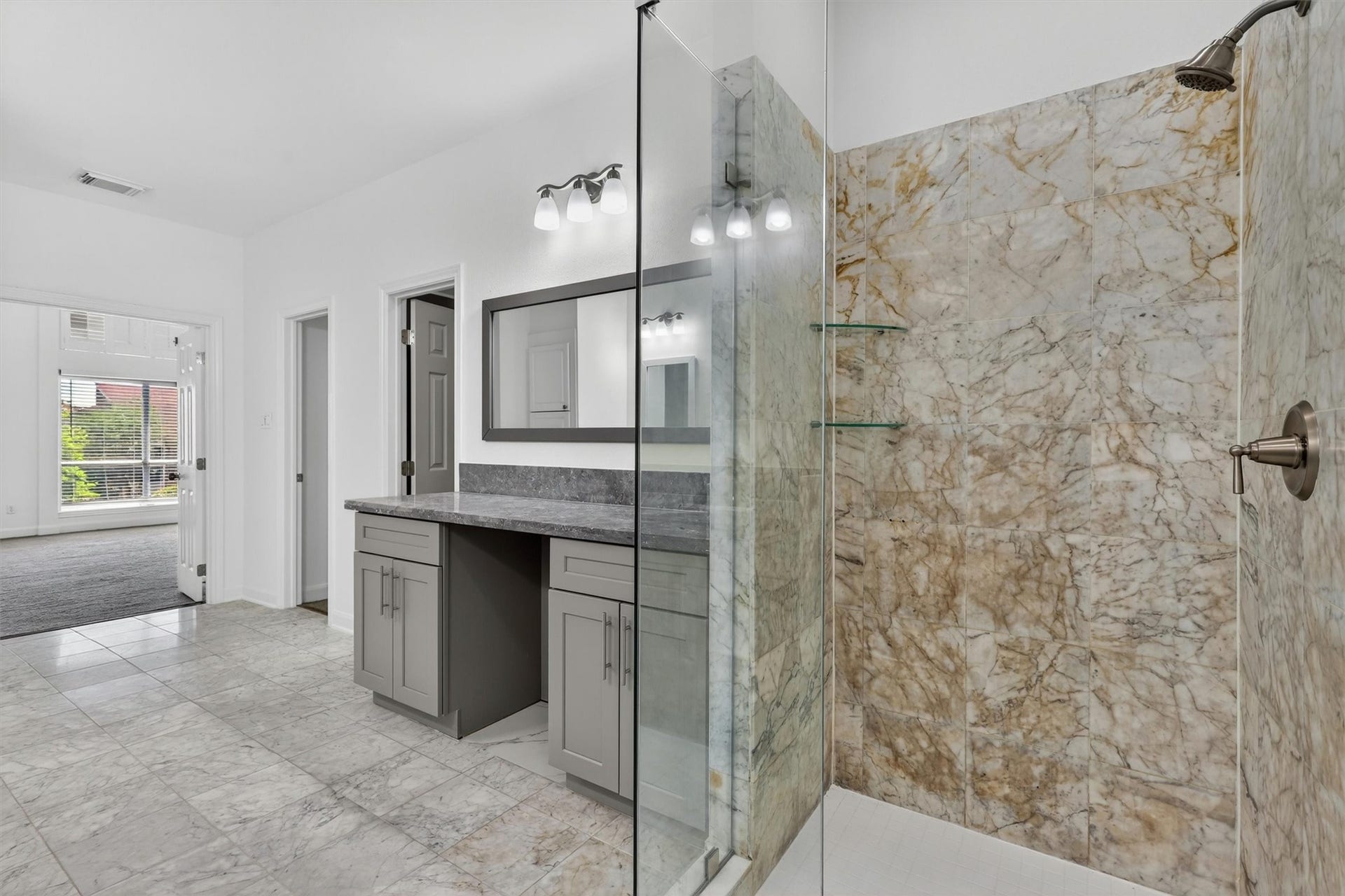 4720 Post Oak Timber Drive, #23, Houston, TX 77056 Spa-inspired primary bathroom featuring a frameless glass walk-in shower with designer marble-look tile, oversized vanity with granite countertops, modern cabinetry, and updated lighting. Bright open layout with luxury finishes creates a relaxing owners retreat buyers will love.