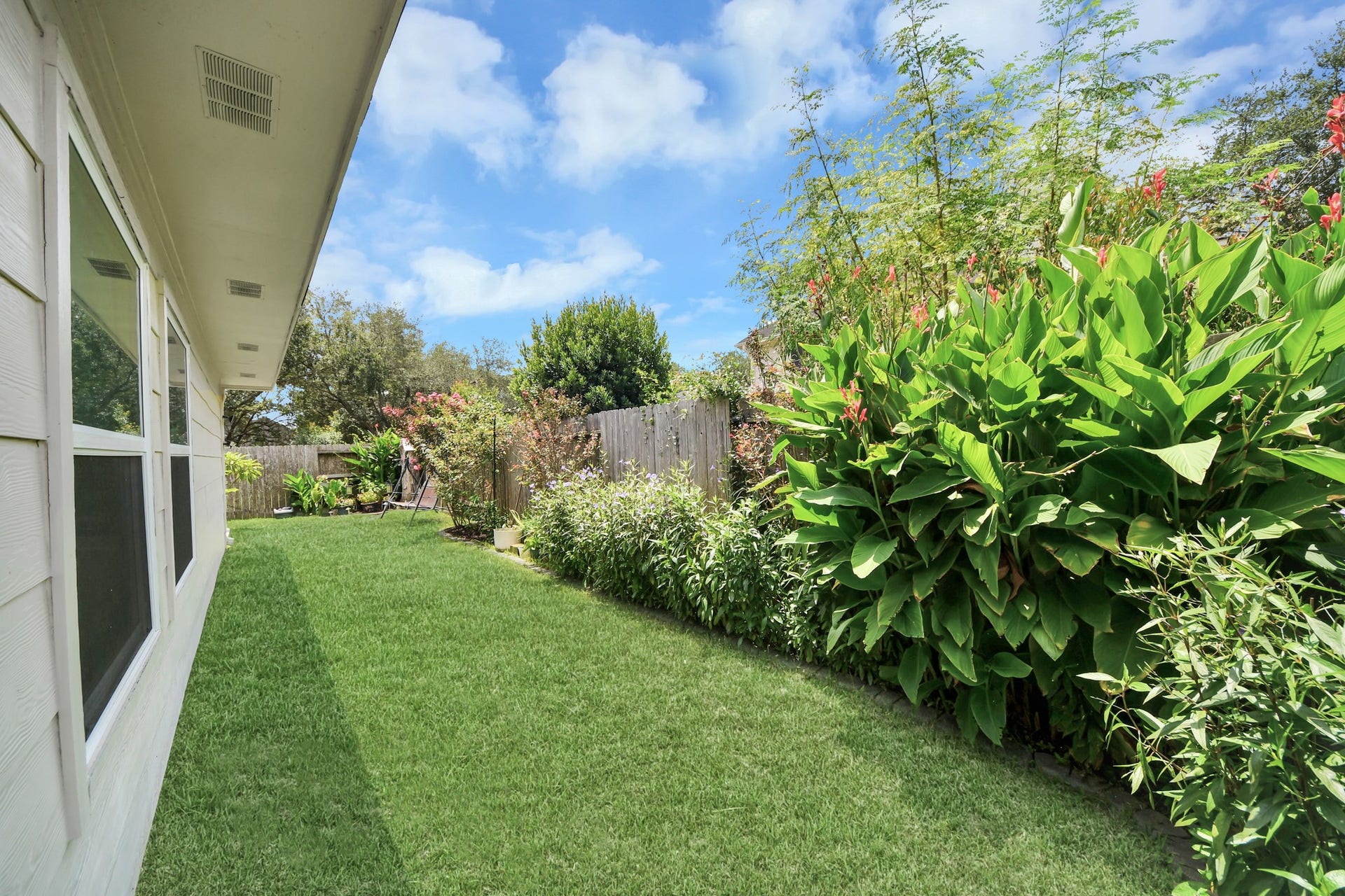 4634 Jaymar Dr, Sugar Land, TX 77479 Lush landscaping creates a peaceful backyard setting with additional usable lawn space.