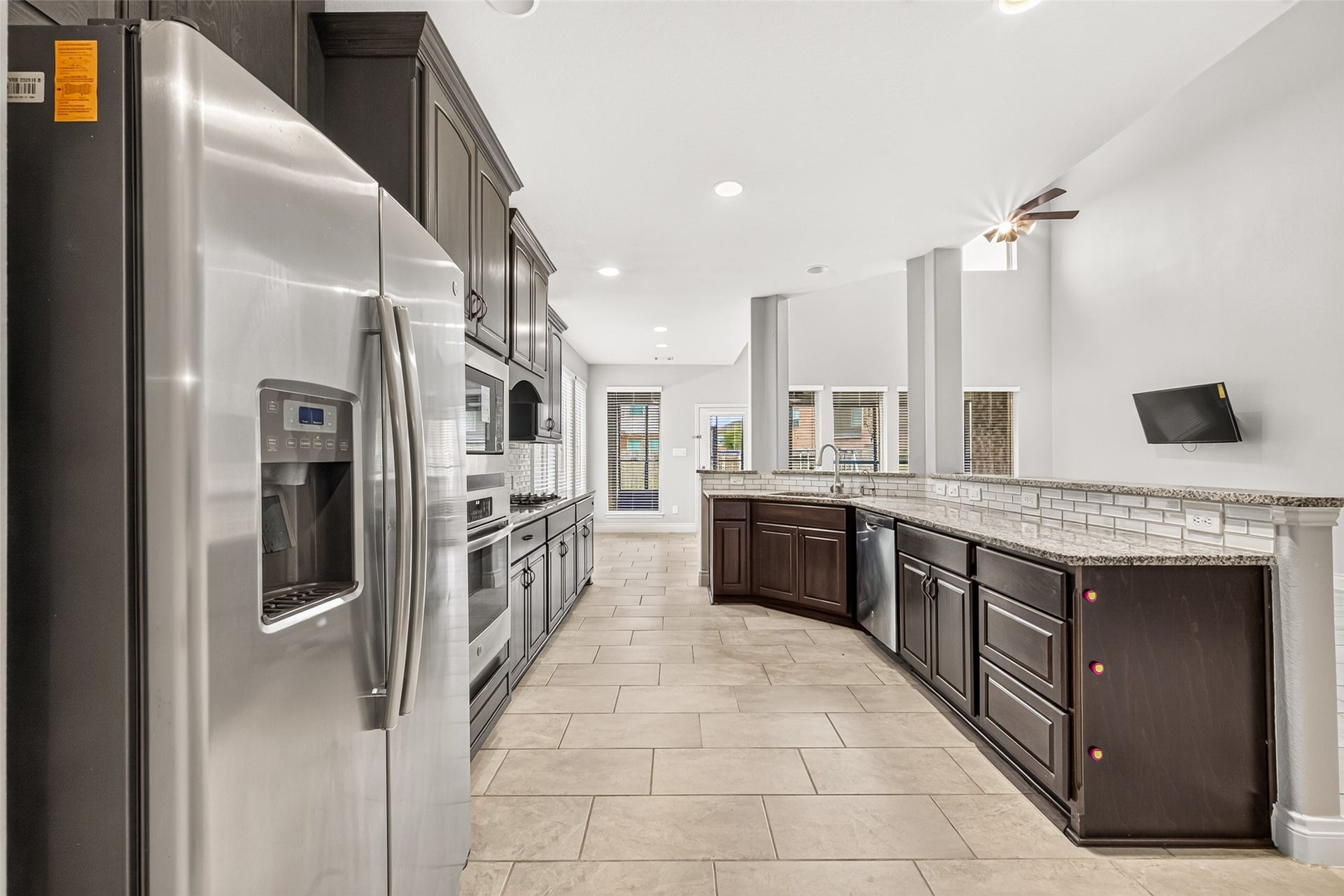 23335 Peareson Bend Lane, Richmond, TX 77469 Beautiful kitchen featuring built-in appliances, granite countertops, and elegant cabinetry with crown molding, creating a perfect blend of style, functionality, and timeless appeal.