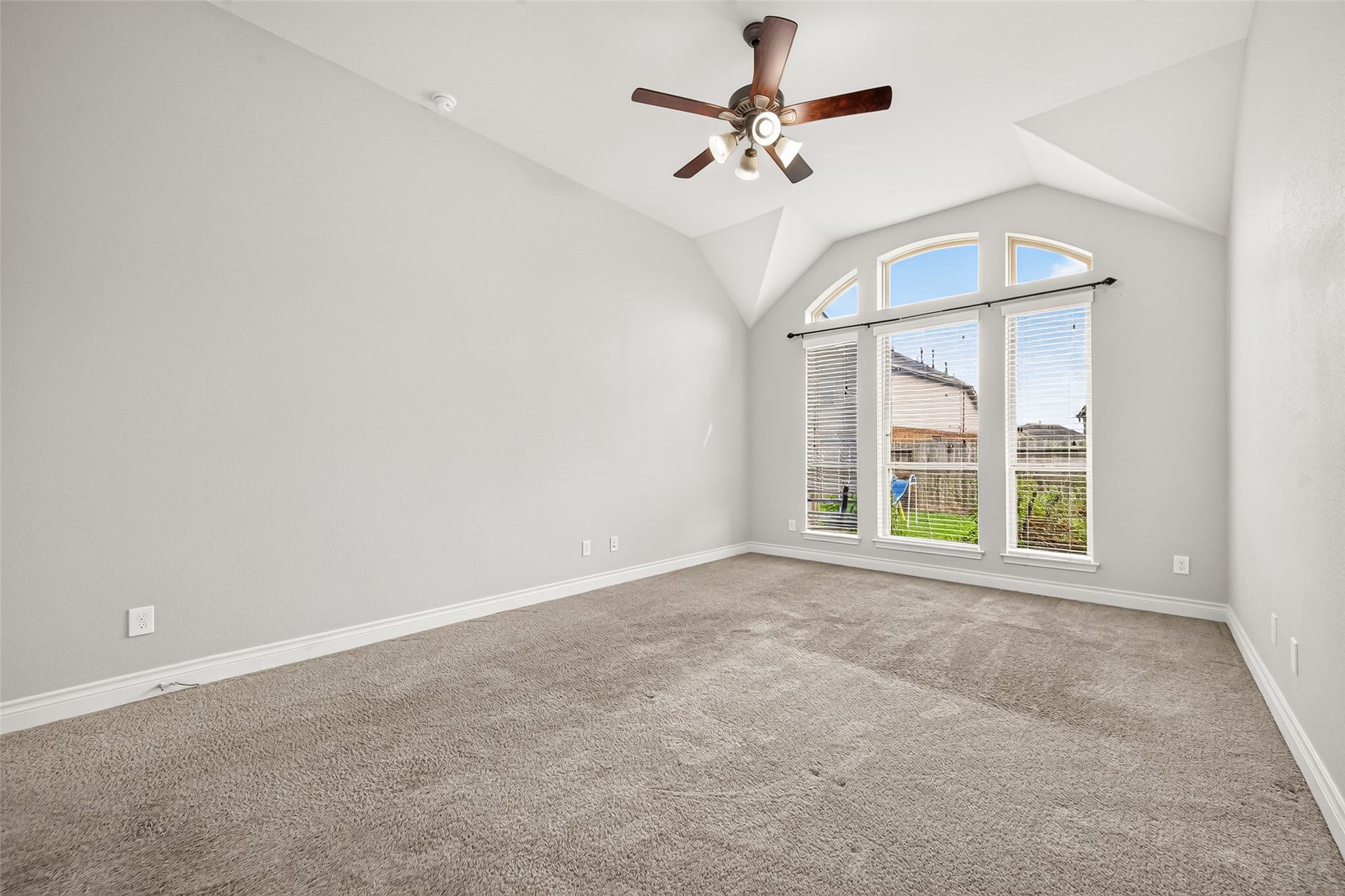 23335 Peareson Bend Lane, Richmond, TX 77469 Spacious first-floor primary suite featuring soaring ceilings and large windows that fill the room with abundant natural light, creating a bright, airy, and inviting retreat