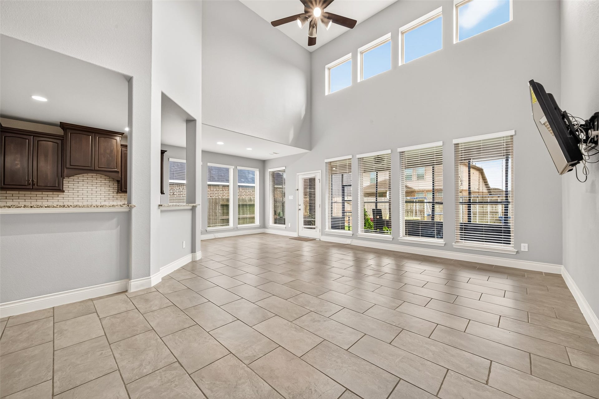 23335 Peareson Bend Lane, Richmond, TX 77469 Stunning family room featuring soaring ceilings and a dramatic wall of windows that flood the space with abundant natural light, creating a bright, open, and inviting atmosphere