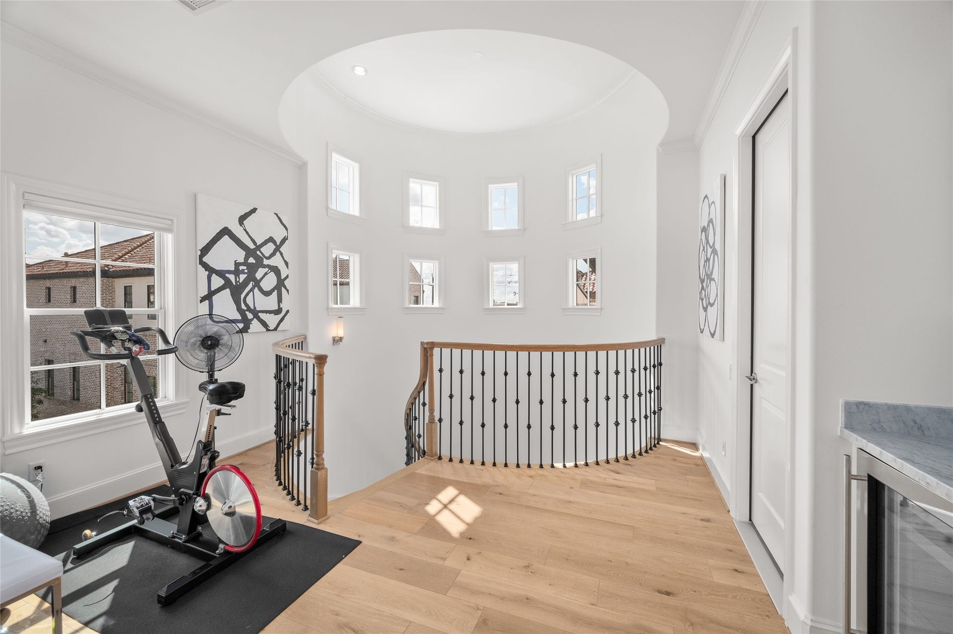 7554 Little Caprese Lane, Houston, TX 77055 Light filled landing with soaring ceilings, curved staircase, beautiful hardwood floors, and an abundance of windows.