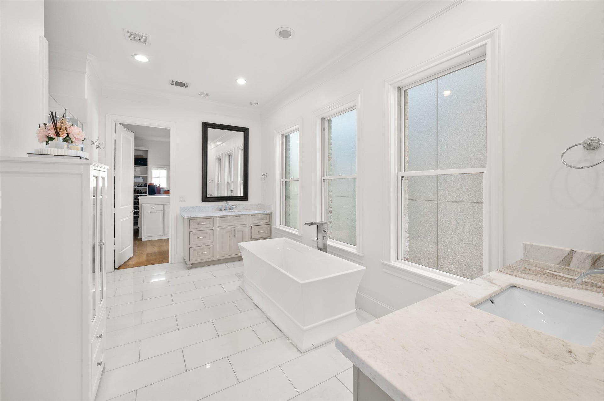 7554 Little Caprese Lane, Houston, TX 77055 Beautifully appointed primary suite bath featuring a freestanding soaking tub, marble countertops, dual vanities, and abundant natural light.