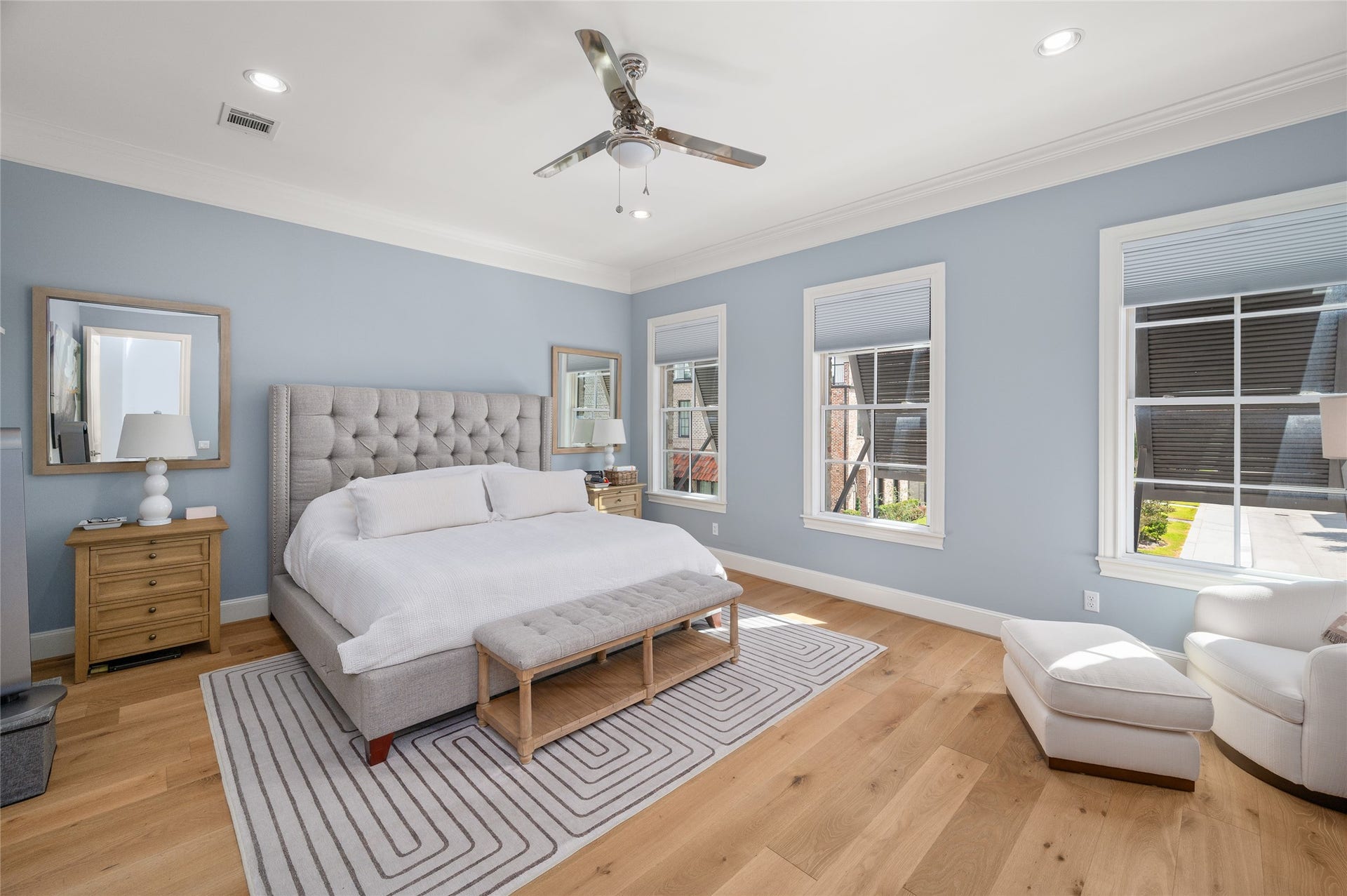 7554 Little Caprese Lane, Houston, TX 77055 Generously proportioned primary bedroom suite with soft blue walls, wide-plank hardwood flooring, and multiple windows providing natural light.