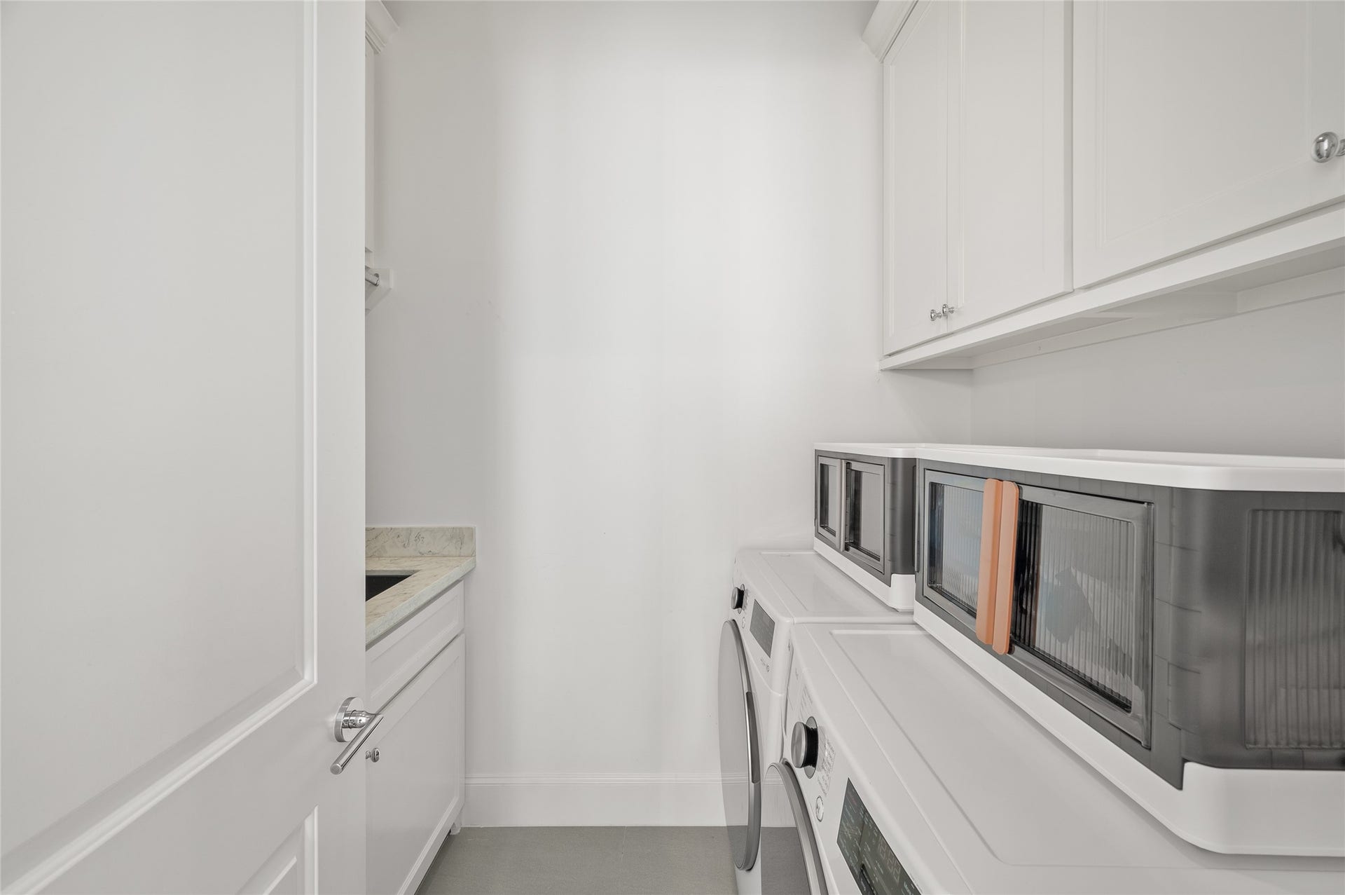 7554 Little Caprese Lane, Houston, TX 77055 Dedicated utility room featuring side-by-side washer and dryer, upper cabinetry, countertop space, and a utility sink.