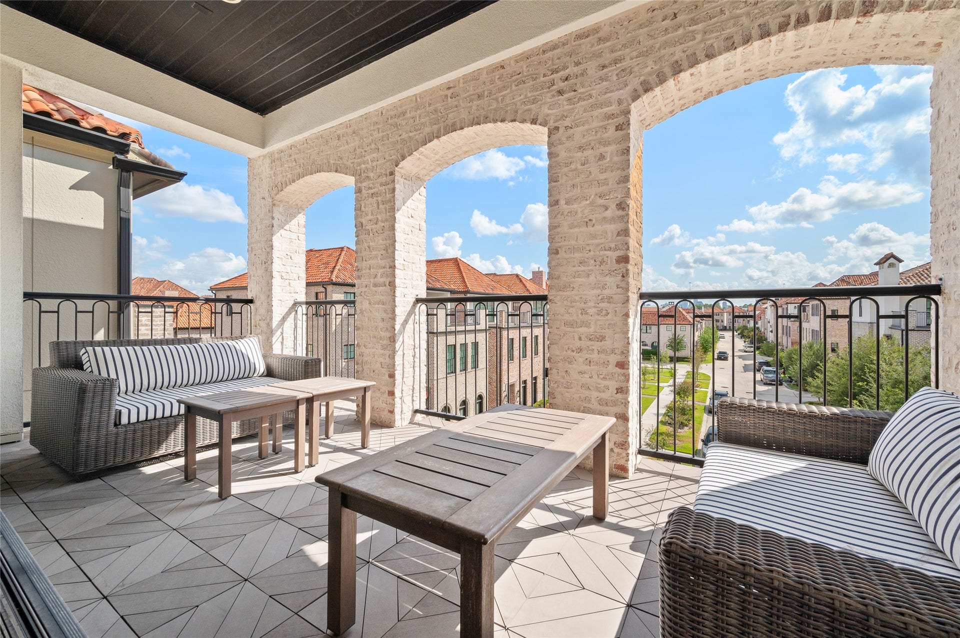 7554 Little Caprese Lane, Houston, TX 77055 Expansive covered balcony with charming brick archways, outdoor seating, and picturesque neighborhood views.