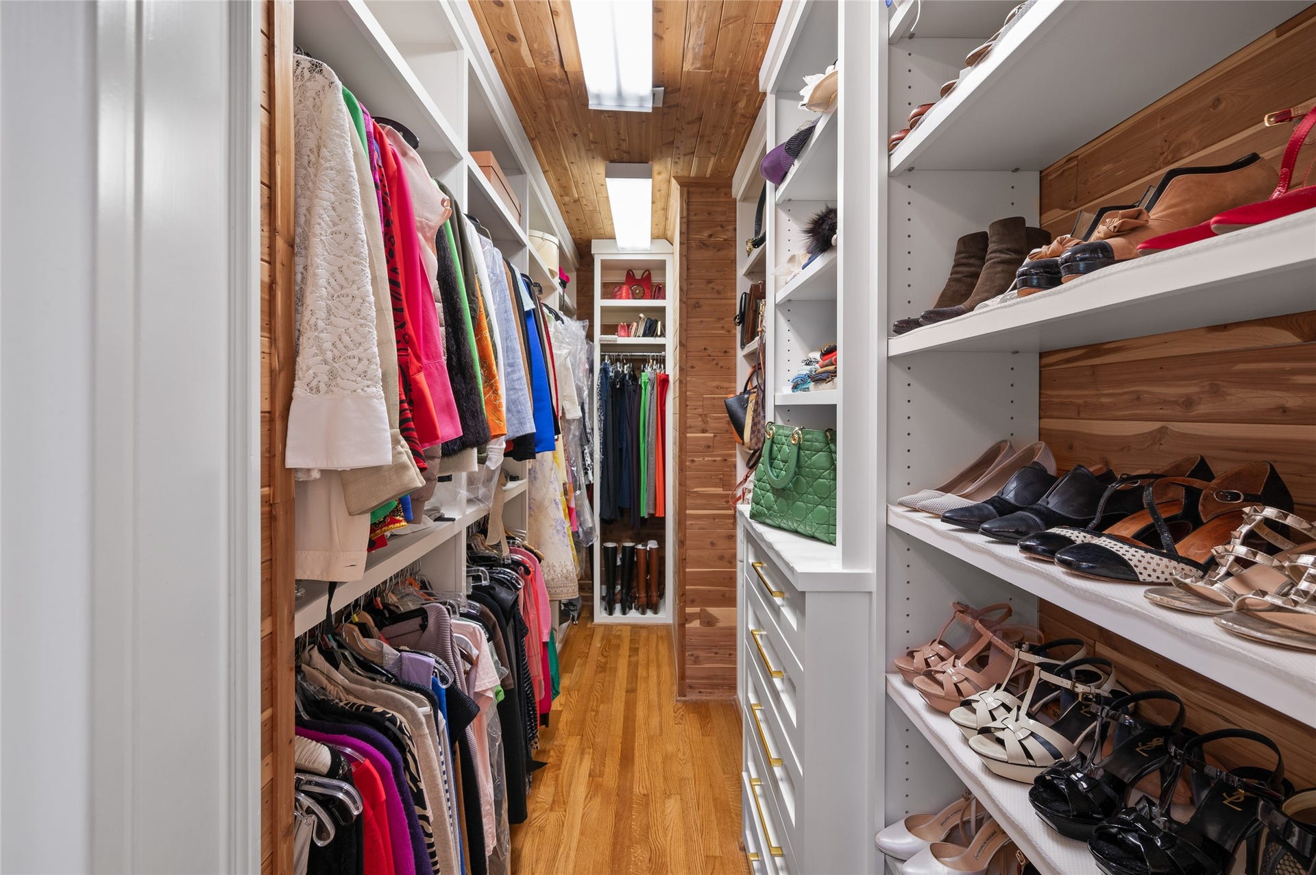[Primary Closet - 1 of 2]
This custom-fitted closet, 1 of 2 in the primary suite, includes cedar-plank walls and ceiling.