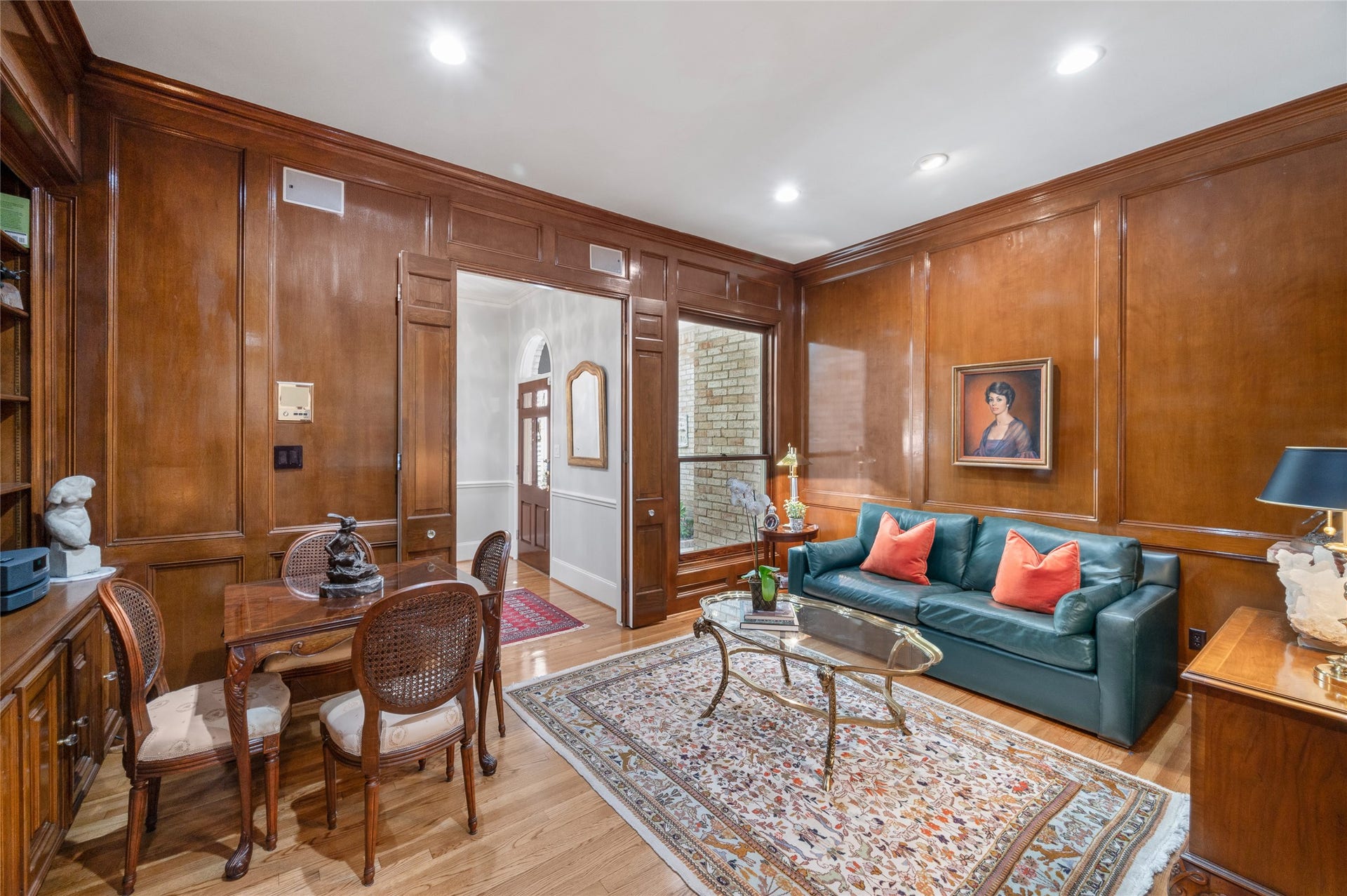 [1st-Floor Study] 
This inviting study flanks the foyer. Note rich paneling and built-in book / display cabinet (left).