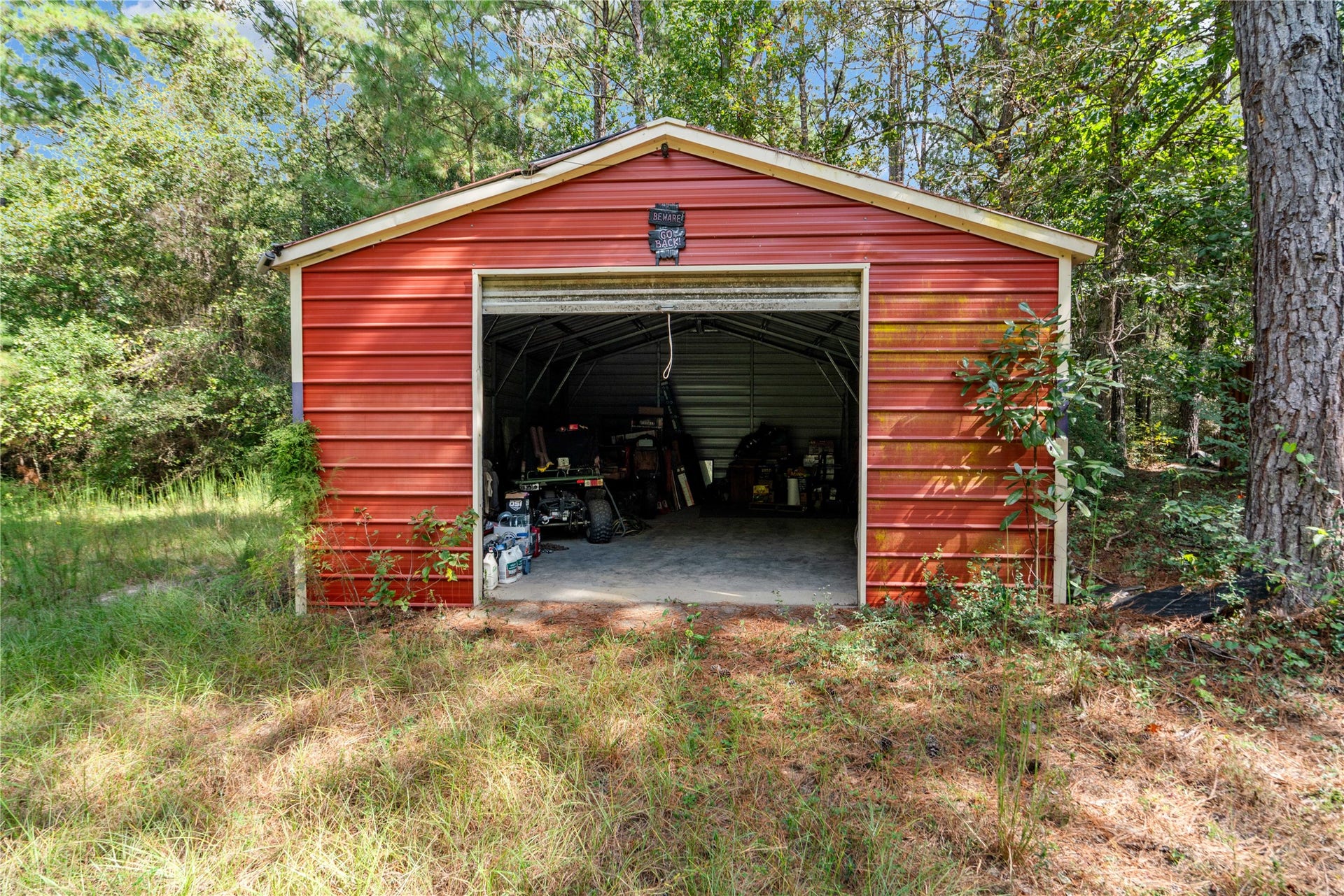 21203 Peach Wood Court, Cleveland, TX 77328 640 sqft metal shop nestled in the woods with a separate generator for electrical.