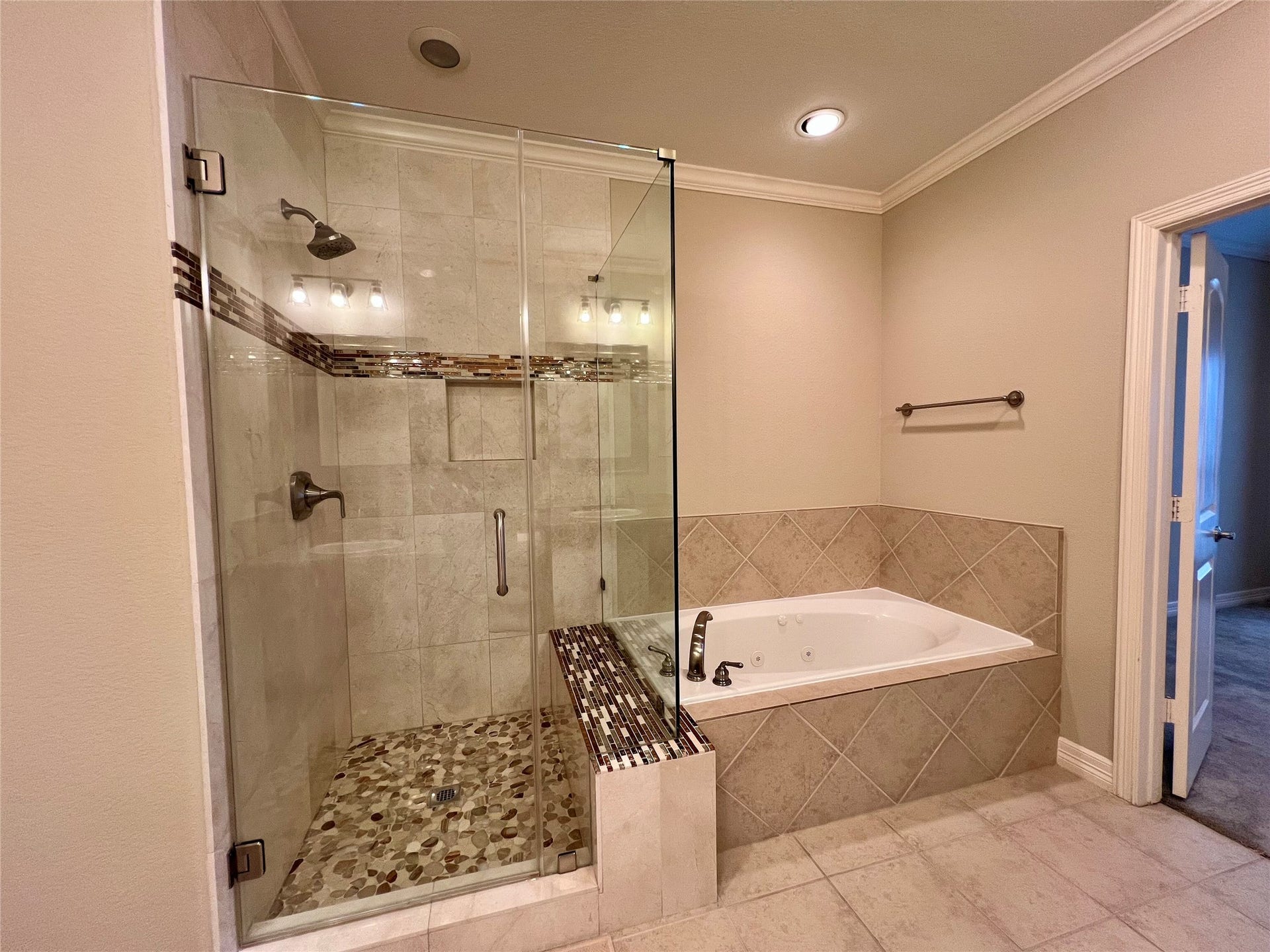 1625 Cohn Street, Houston, TX 77007 A modern glass-enclosed shower with stylish tilework and a separate built-in bathtub. The neutral tones and recessed lighting create a relaxing atmosphere.