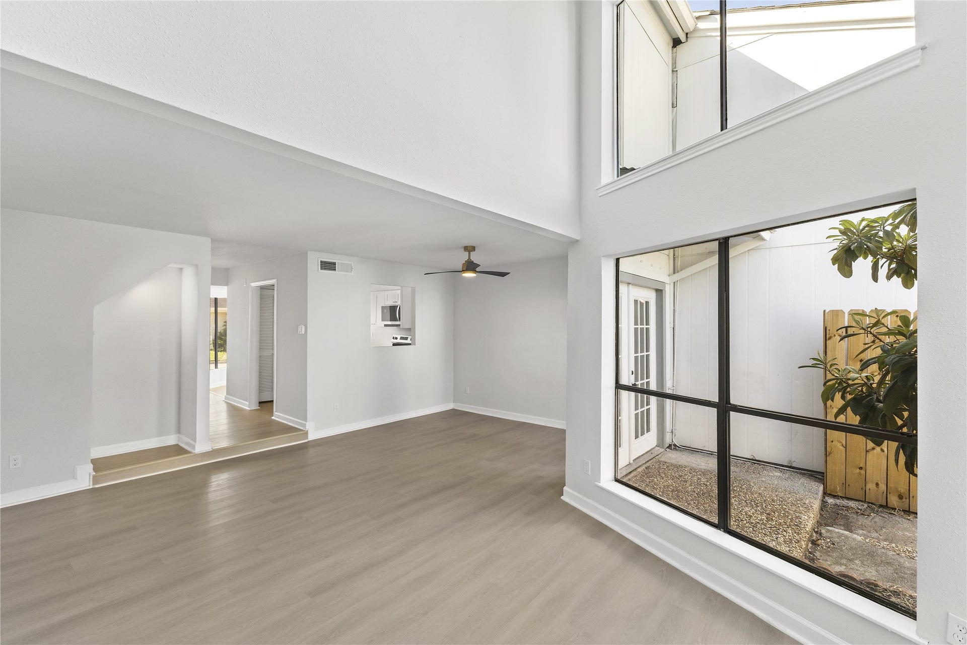 1913 Bittercreek Drive, Houston, TX 77042 Soaring ceilings and expansive two-story windows bring natural light into the living area, while a pass-through to the kitchen keeps the main gathering spaces connected.