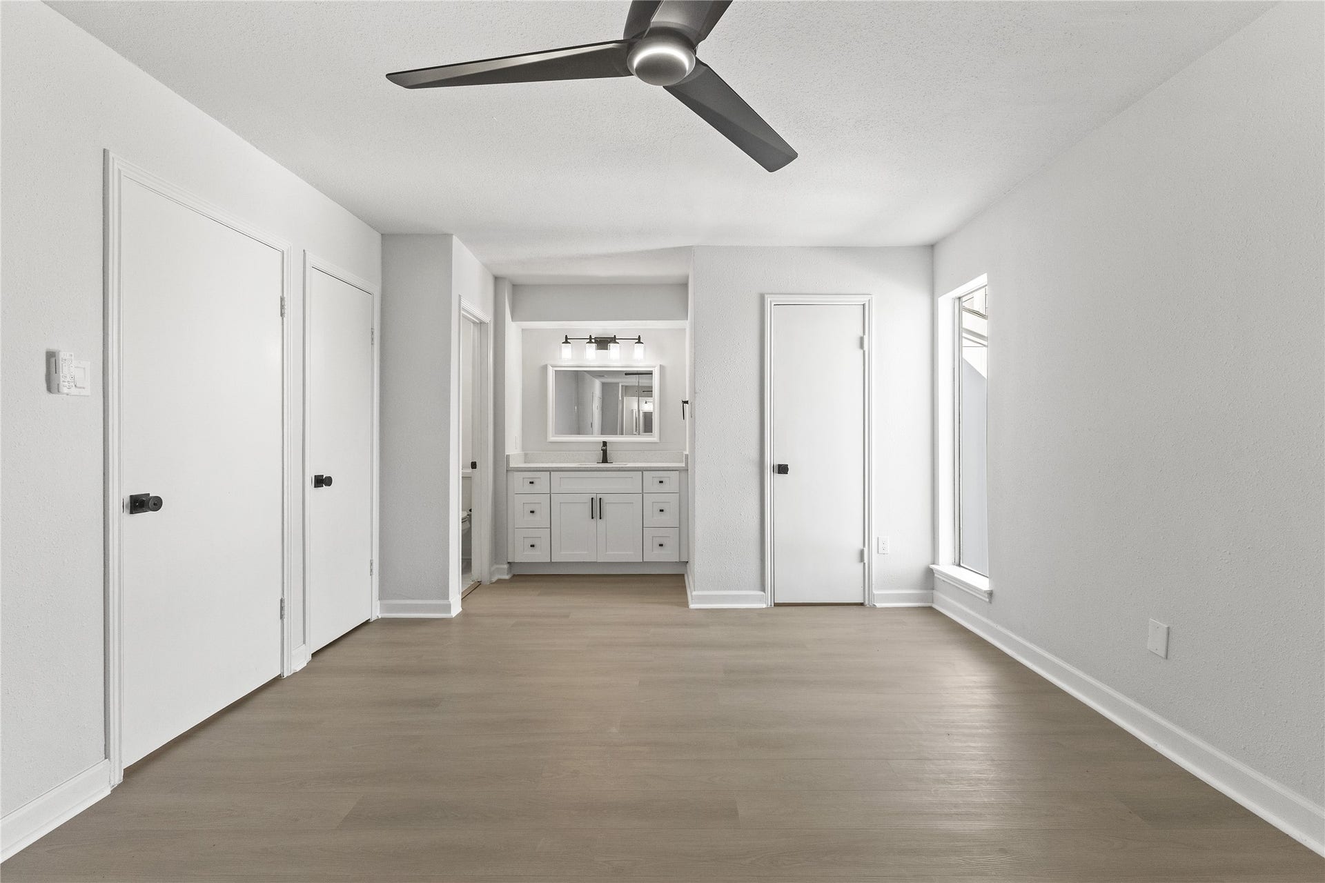 1913 Bittercreek Drive, Houston, TX 77042 A view from the primary bedroom leads toward the ensuite, showcasing the homes thoughtful, connected layout.
