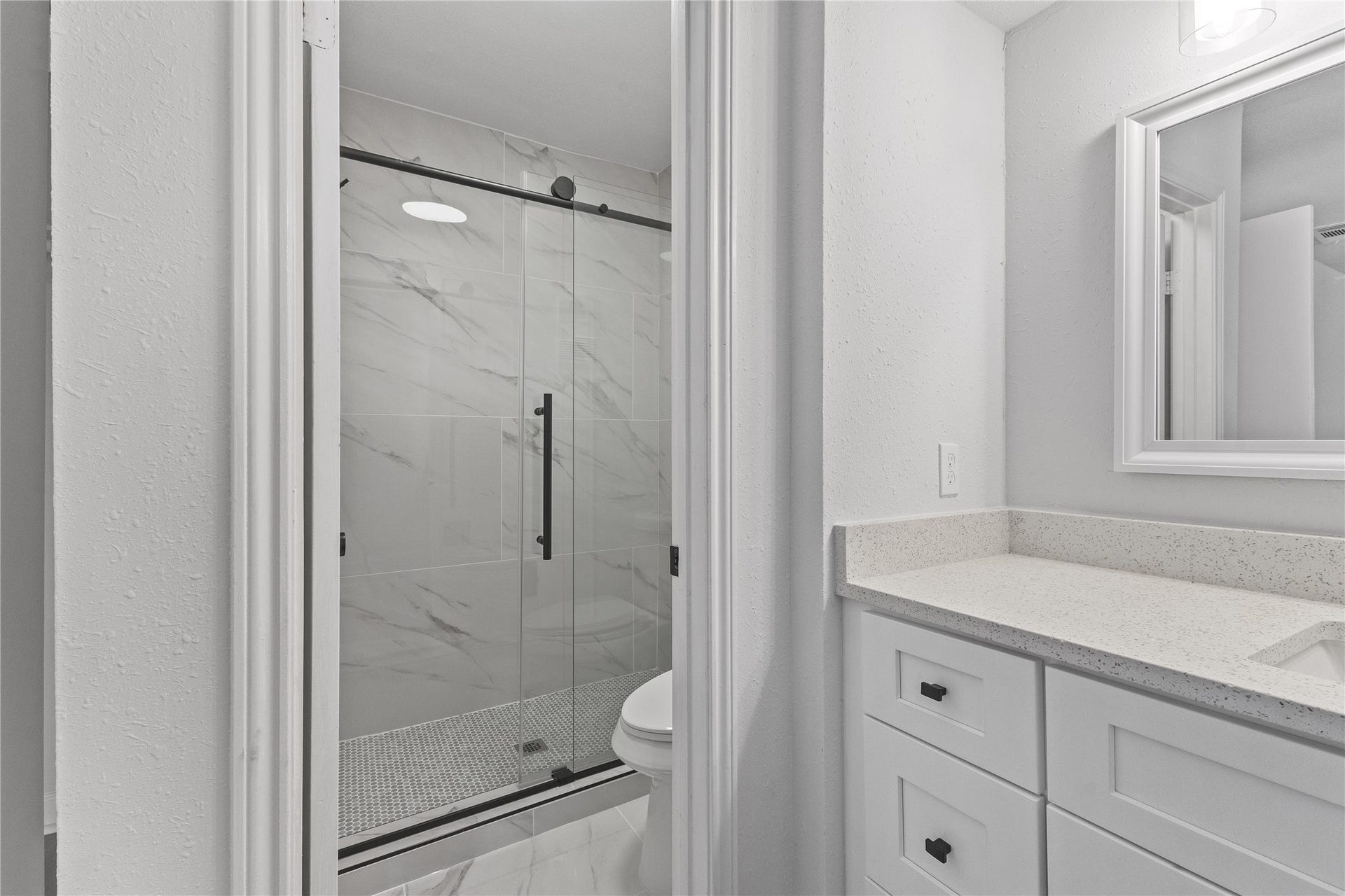 1913 Bittercreek Drive, Houston, TX 77042 The ensuite bathroom features a glass-enclosed shower, marble-look tile, and a quartz-top vanity for a polished, spa-like feel.
